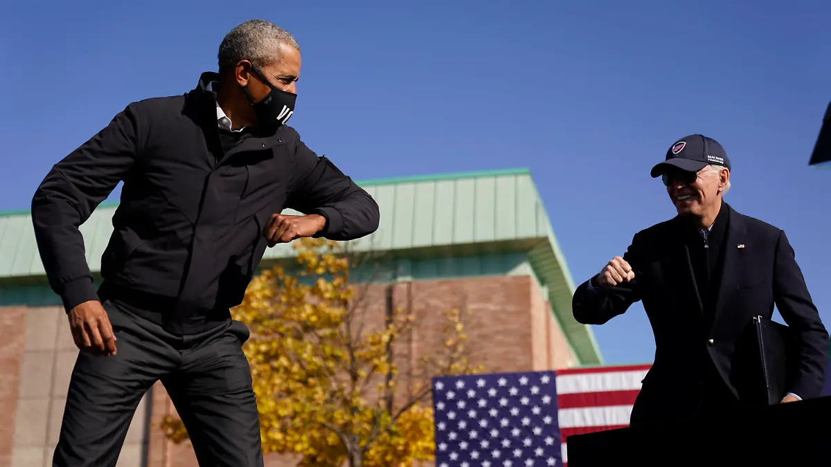 31.10.2020, USA, Flint: Joe Biden (r), Präsidentschaftskandidat der Demokraten, und Barack Obama, ehemaliger Präsident der USA, begrüßen sich bei einer Wahlkampfveranstaltung an einer Hochschule. Foto: Andrew Harnik/AP/dpa +++ dpa-Bildfunk +++