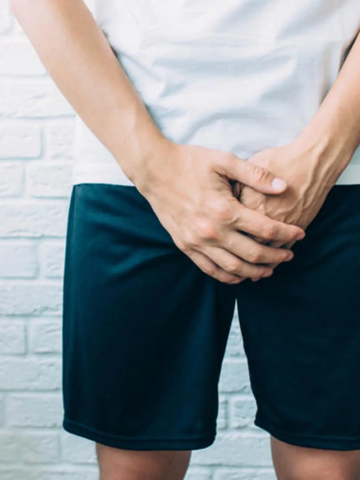 man wearing shorts holding genitals. Men's health, venereologist, sexual disease