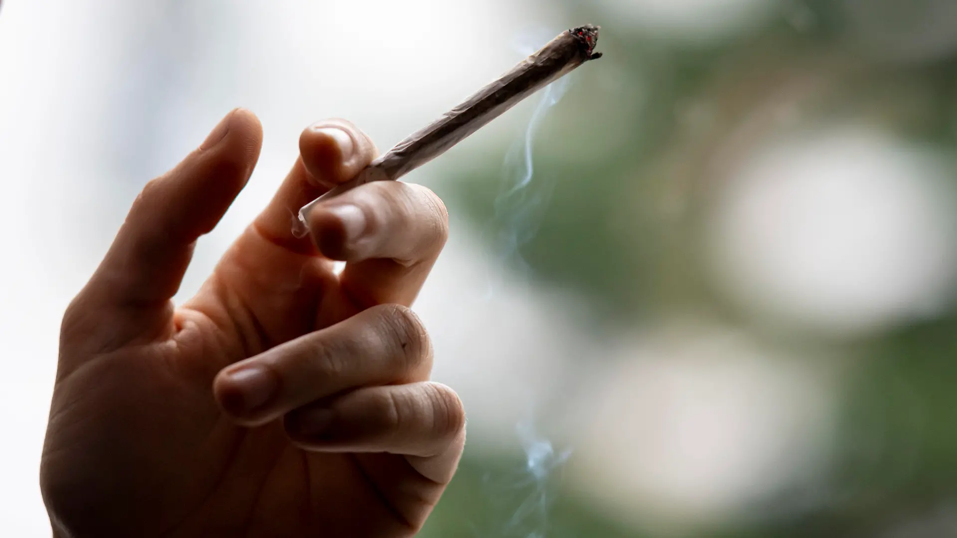 ARCHIV - 27.11.2021, Berlin: Eine Person raucht einen Joint. Die geplante Legalisierung von Cannabis in Deutschland birgt laut dem UN-Drogenkontrollrat (INCB) das Risiko von erhöhtem Konsum unter Jugendlichen und eines wachsenden Schwarzmarkts für diese Droge. (zu dpa "UN-Drogenkontrollrat warnt Deutschland vor Cannabis-Legalisierung") Foto: Fabian Sommer/dpa +++ dpa-Bildfunk +++