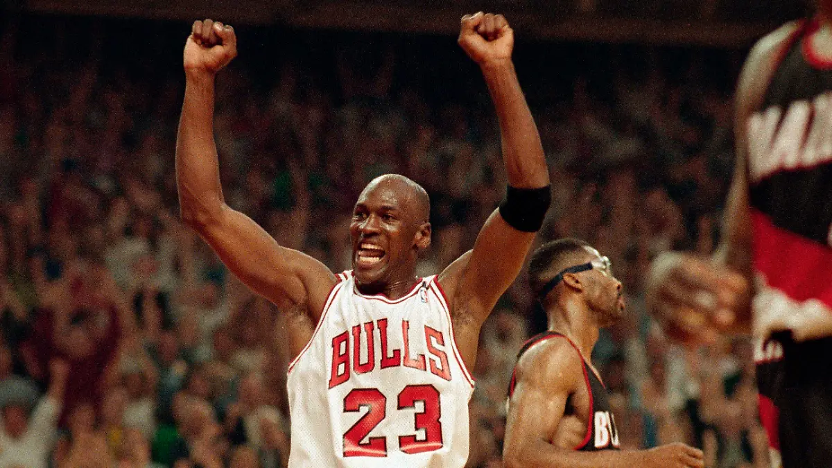 FILE - In this June 14, 1992, file photo, Michael Jordan celebrates the Bulls win over the Portland Trail Blazers in the NBA Finals in Chicago. Decades after Jordan's groundbreaking departure from college, March Madness and the NBA's mega-millions have taken all the novelty out of leaving early for the pros. (AP Photo/John Swart, File)