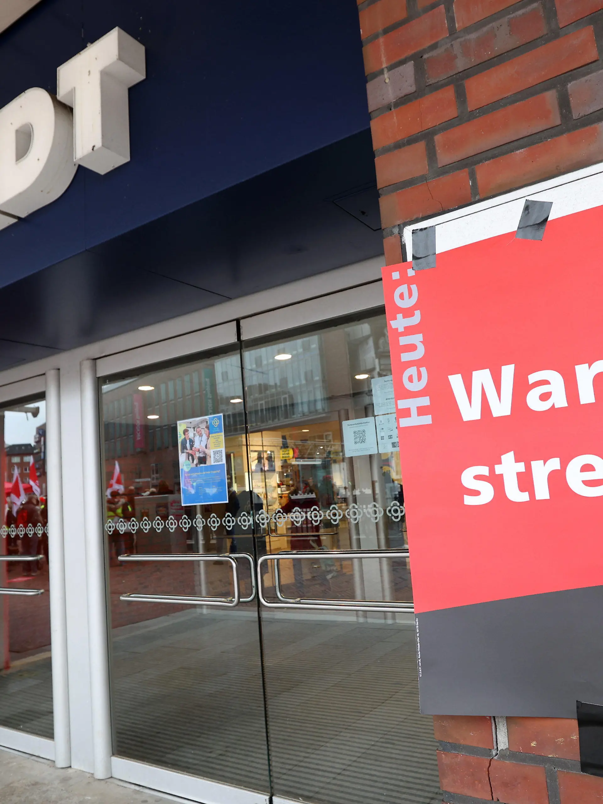 08.04.2023, Hamburg: Ein Plakat mit der Aufschrift "Warnstreik" ist am Eingang zu einem Galeria-Karstadt-Kaufhaus in Hamburg in Hamburg zu sehen. Beschäftigte aller Hamburger Galeria-Warenhäuser sind am Samstag in einen ganztägigen Warnstreik getreten. Foto: Bodo Marks/dpa +++ dpa-Bildfunk +++