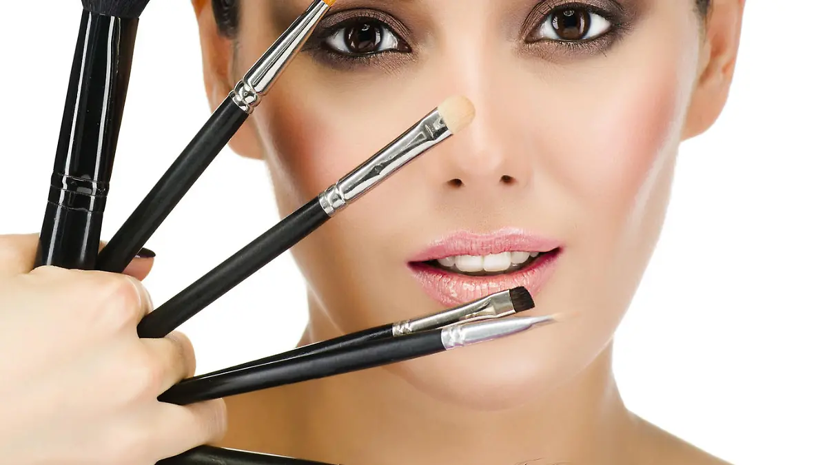 portrait of attractive caucasian woman brunette isolated on white studio shot looking at camera face skin makeup closeup brushes