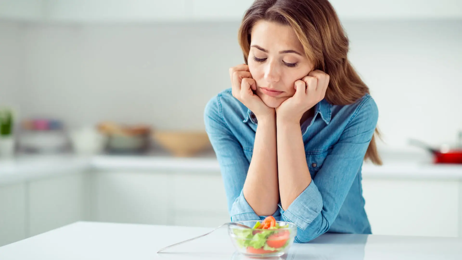 Frau schaut skeptisch auf kleine Schüssel Salat