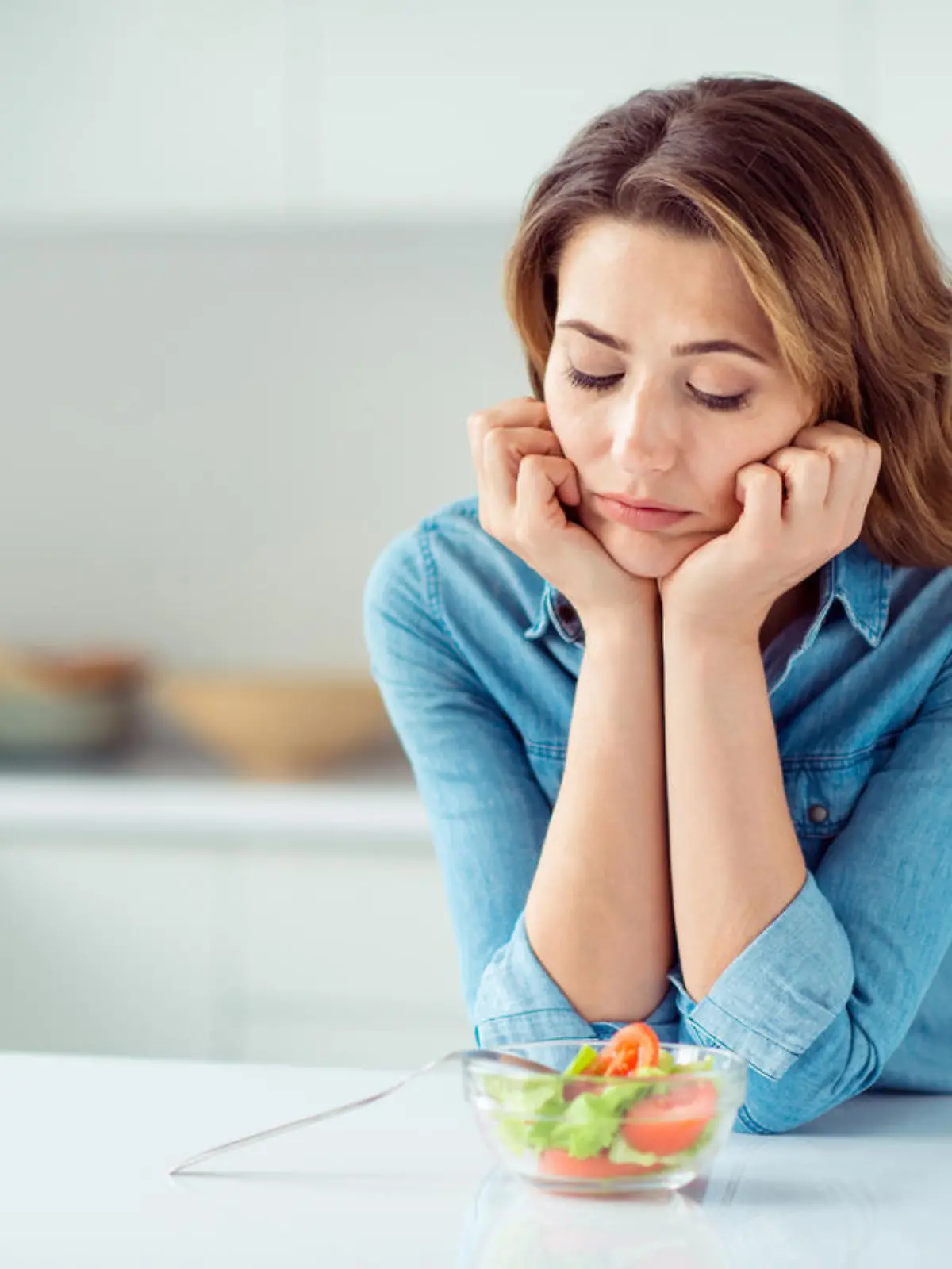 Frau schaut skeptisch auf kleine Schüssel Salat