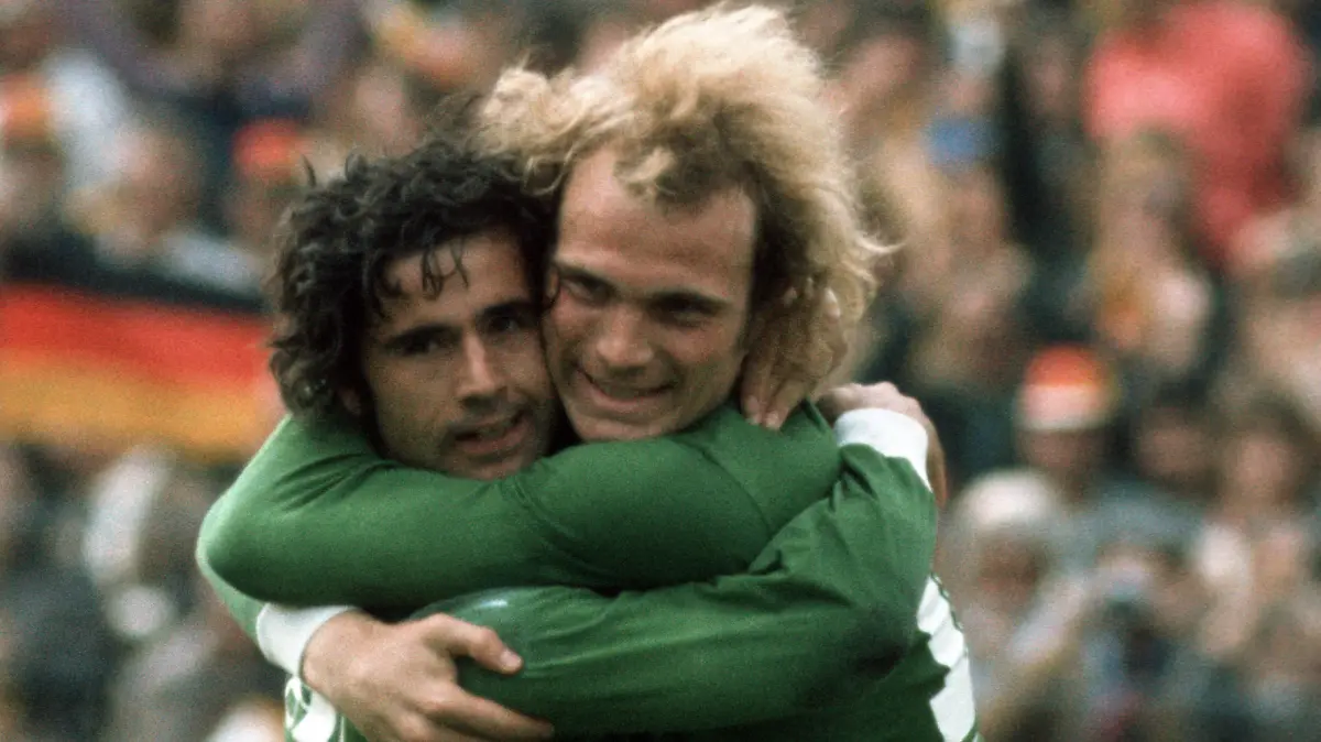 Die deutschen Fußballnationalspieler Gerd Müller (l) und Uli Hoeneß (r) freuen sich am 18.06.1974 bei der Fußballweltmeisterschaft in Hamburg. Foto: Natascha Haupt +++(c) Picture-Alliance / ASA+++