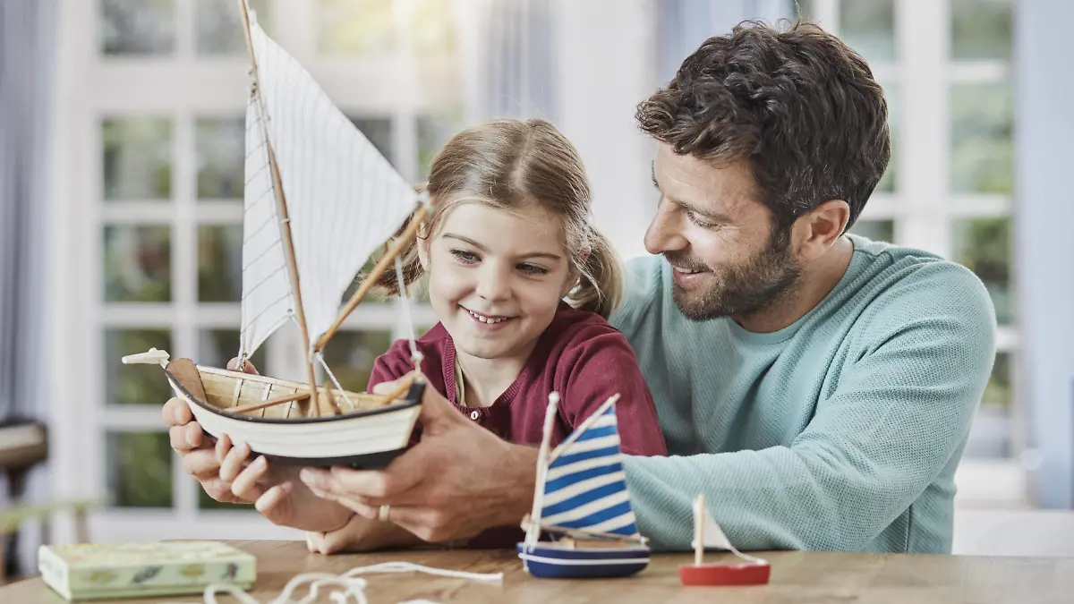 Happy father and daughter playing with model boat at home model released Symbolfoto property released PUBLICATIONxINxGERxSUIxAUTxHUNxONLY RORF01396  