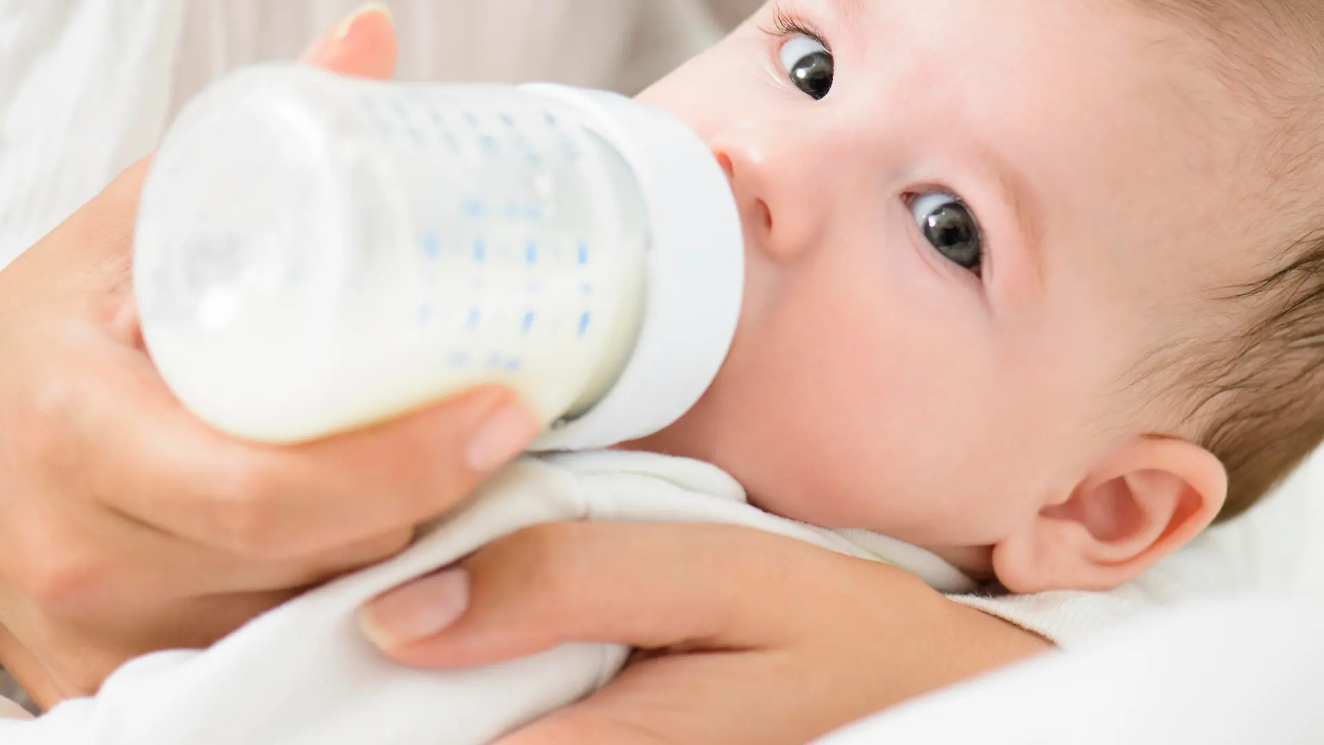A detail shot of cute baby drinking milk from bootle