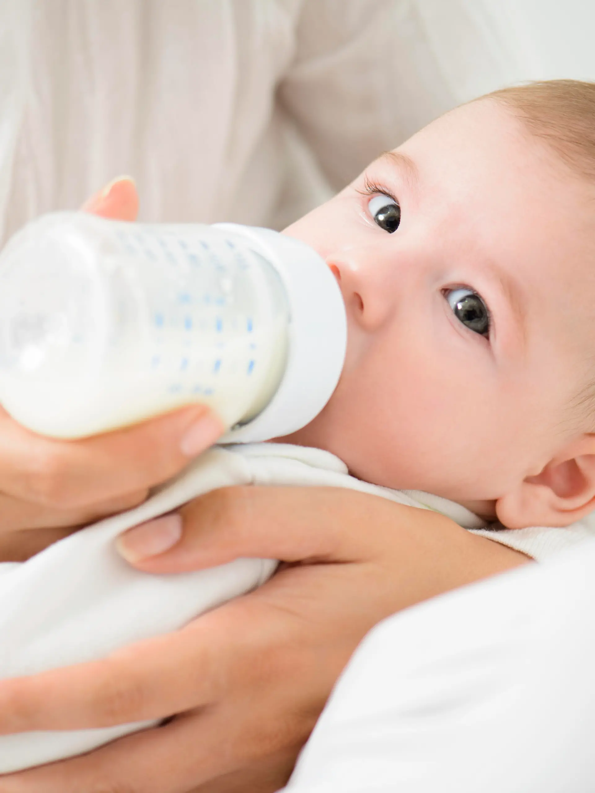 A detail shot of cute baby drinking milk from bootle