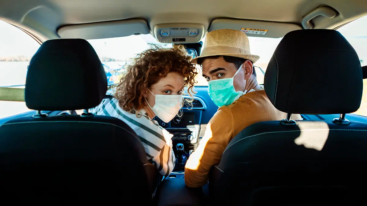 Mann und Frau mit Corona-Maske im Auto
