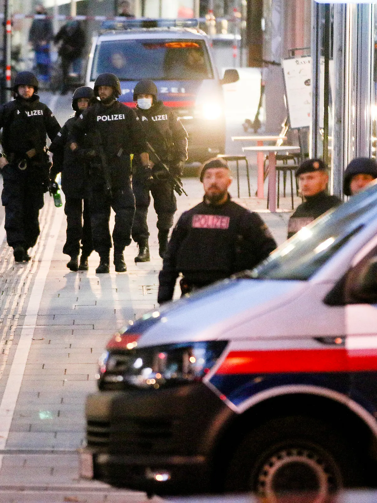 03.11.2020, Österreich, Wien: Bewaffnete Polizisten patrouillieren am frühen Morgen auf einer abgesperrten Straße nach einem Schusswechsel im Stadtzentrum. Die Terrorattacke von Wien geht nach den Worten von Österreichs Innenminister Nehammer auf das Konto mindestens eines islamistischen Terroristen. Foto: Ronald Zak/AP/dpa +++ dpa-Bildfunk +++