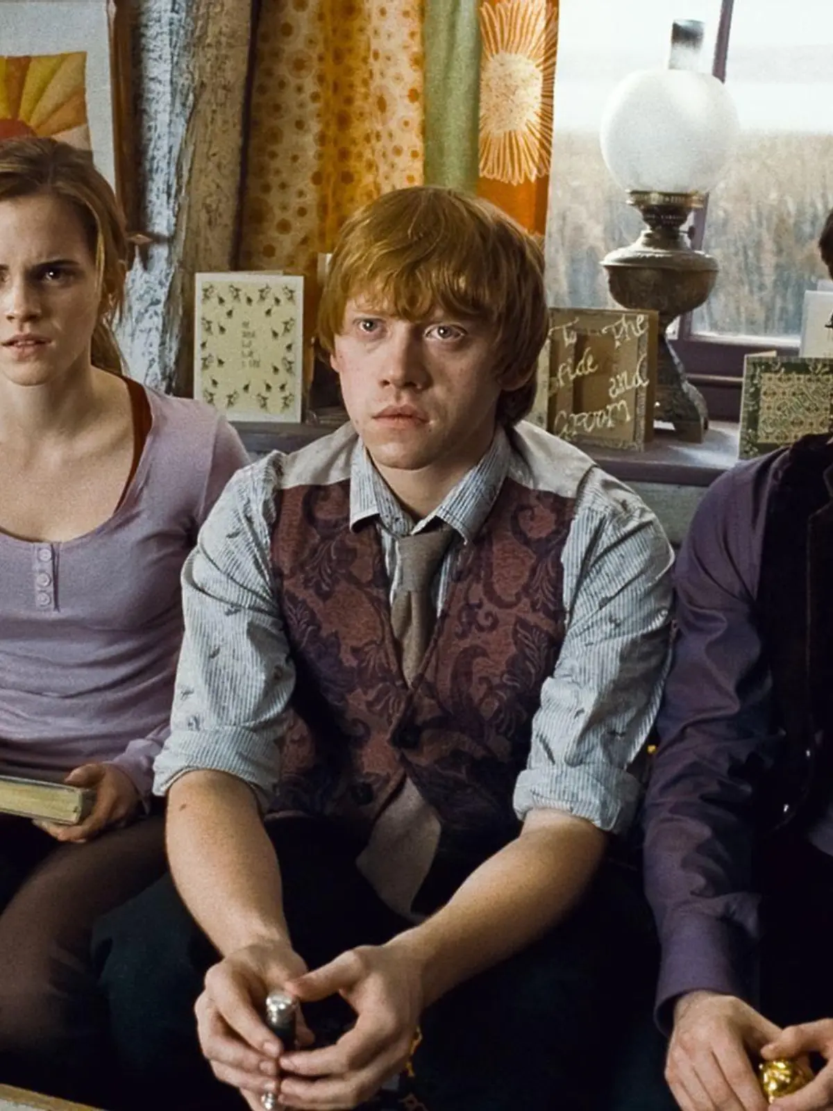 Hermine (Emma Watson), Ron (Rupert Grint, M.) und Harry (Daniel Radcliffe) wissen noch nicht, was sie mit den von Dumbledore geerbten Stücken anfangen sollen.