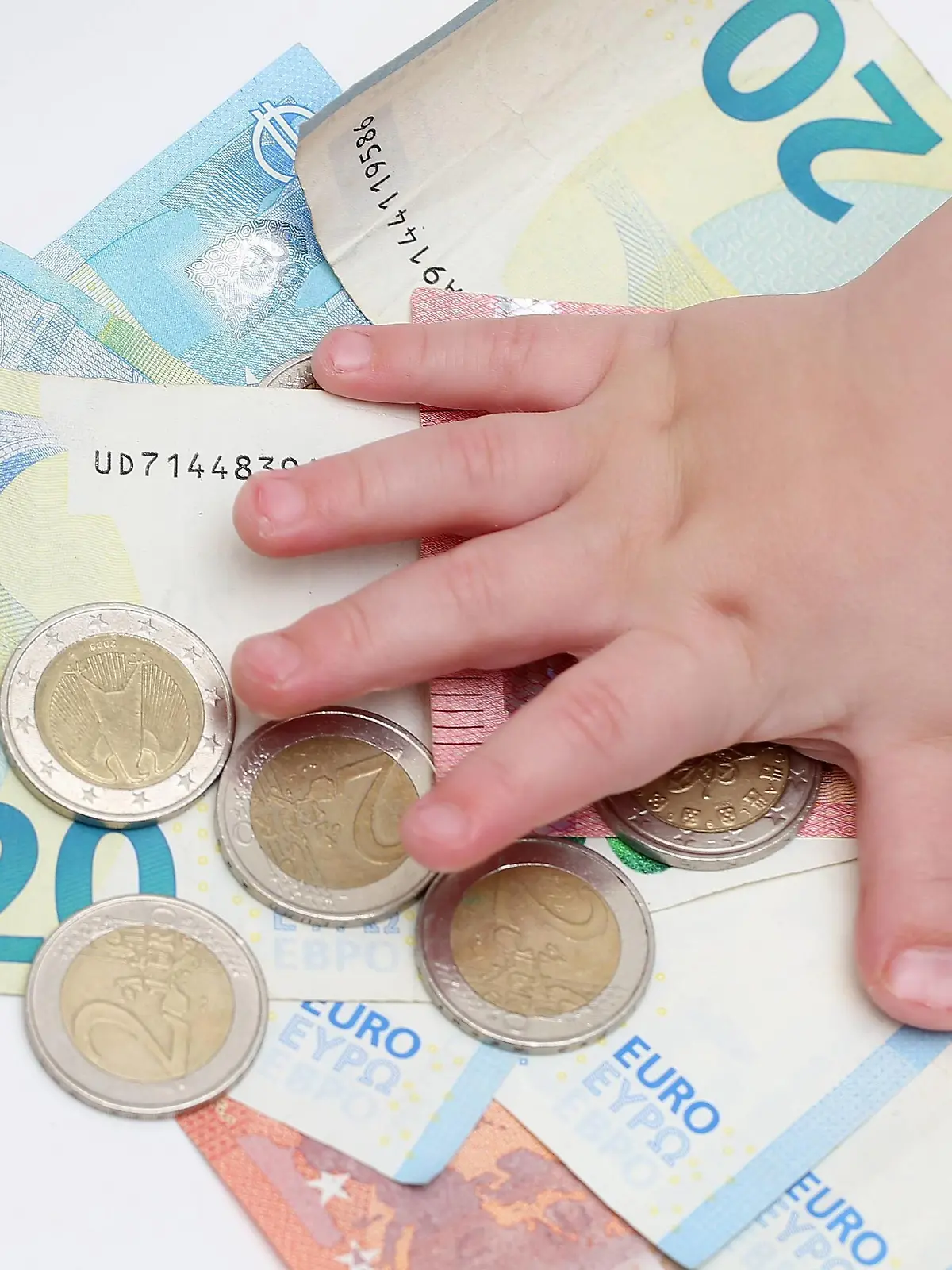  Symbolbild Geld 28.11.18, Symbolbild Geld, Kinderhand greift nach Stapel von 2 Euro Muenzen auf Geldscheinen Berlin Berlin Deutschland *** Symbol picture money 28 11 18 Symbol picture money child hand reaches for stack of 2 Euro coins on banknotes Berlin Berlin Germany