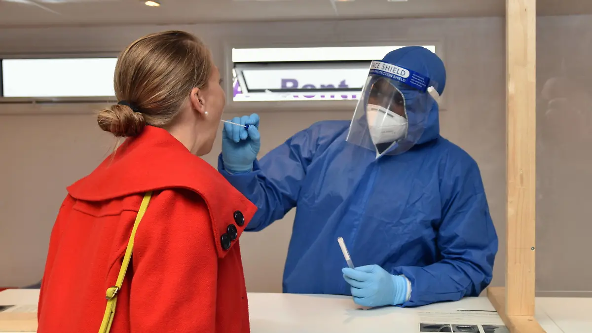 Ein Mitarbeiter der Stadt Köln nimmt im neuen Corona-Testzentrum am Hauptbahnhof bei einer Frau einen Abstrich.bei der der Eröffnung des neuen Corona Testzentrum am Kölner Hauptbahnhof. Hier können sich Reisende aus Risikogebieten innerhalb von 72 Stunden nach ihrer Einreise auf Covid 19 testen lassen. *** An employee of the City of Cologne takes a smear test on a woman in the new Corona Test Centre at Cologne Central Station at the opening of the new Corona Test Centre at Cologne Central Station Here, travellers from risk areas can have themselves tested for Covid 19 within 72 hours of their arrival