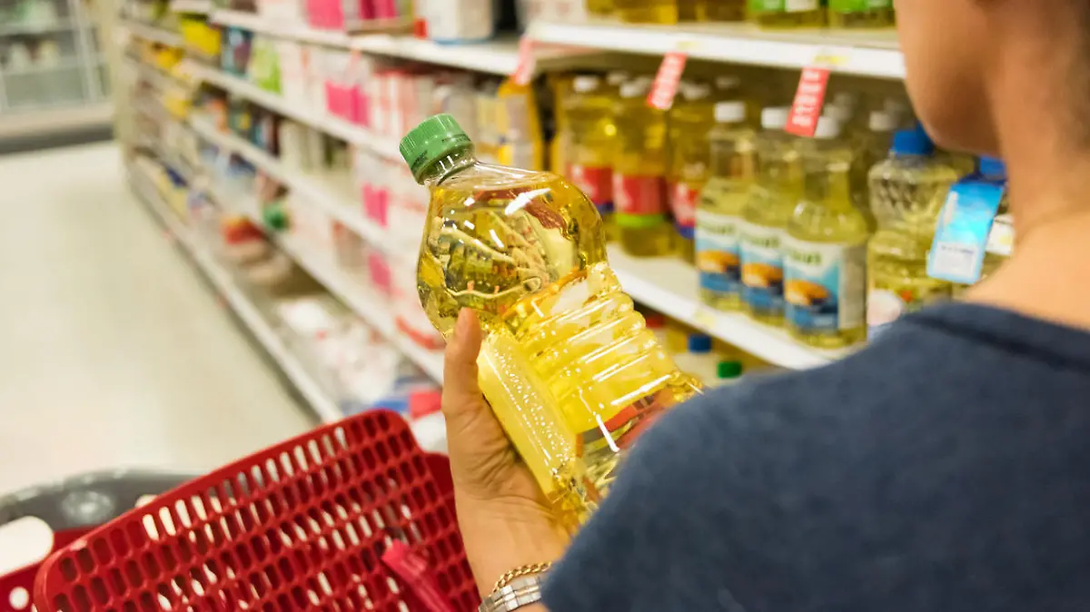 Frau kauft Pflanzenöl im Supermarkt ein