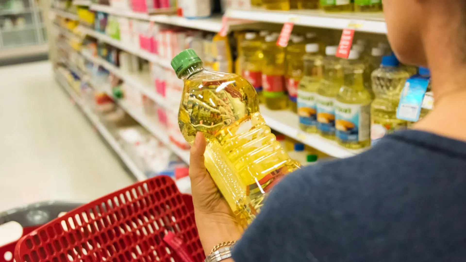 Frau kauft Pflanzenöl im Supermarkt ein
