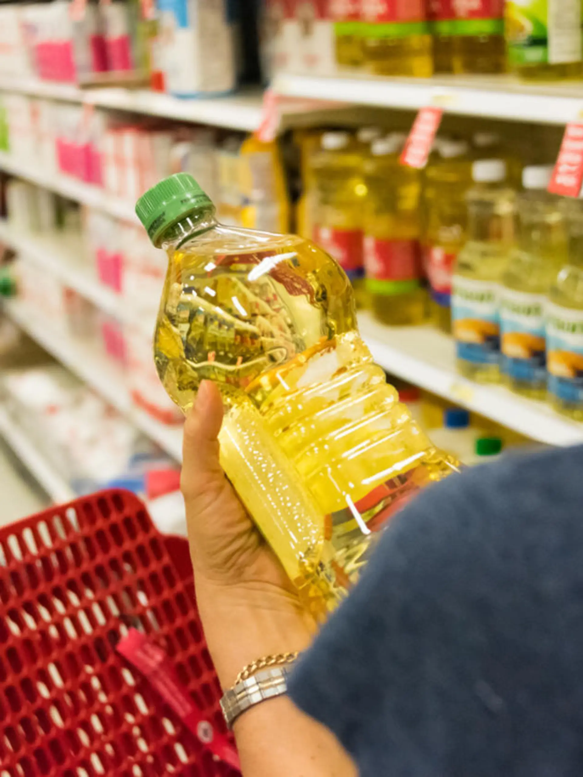 Frau kauft Pflanzenöl im Supermarkt ein