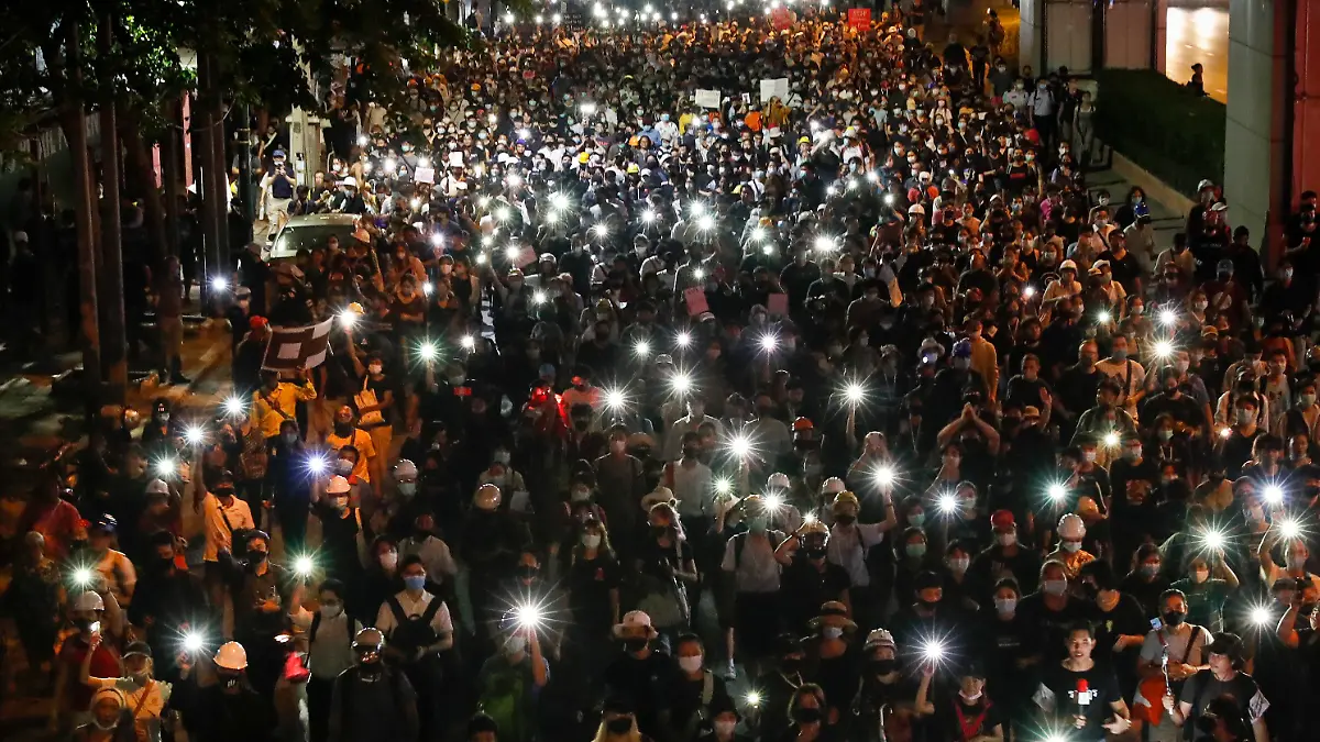 26.10.2020, Thailand, Bangkok: Pro-demokratische Demonstranten leuchten mit ihren Handys bei einem Protestmarsch in Richtung der deutschen Botschaft, um darauf aufmerksam zu machen, dass der thailändische König Vajiralongkorn einen Großteil seiner Zeit in Deutschland verbringt. Deutsche Regierungsvertreter haben kürzlich ihre Besorgnis über politische Aktivitäten des Königs auf deutschem Boden zum Ausdruck gebracht. Foto: Gemunu Amarasinghe/AP/dpa +++ dpa-Bildfunk +++