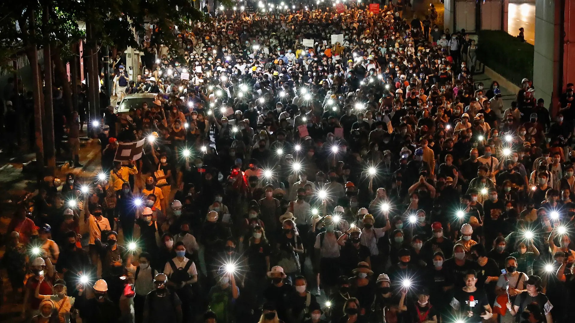 26.10.2020, Thailand, Bangkok: Pro-demokratische Demonstranten leuchten mit ihren Handys bei einem Protestmarsch in Richtung der deutschen Botschaft, um darauf aufmerksam zu machen, dass der thailändische König Vajiralongkorn einen Großteil seiner Zeit in Deutschland verbringt. Deutsche Regierungsvertreter haben kürzlich ihre Besorgnis über politische Aktivitäten des Königs auf deutschem Boden zum Ausdruck gebracht. Foto: Gemunu Amarasinghe/AP/dpa +++ dpa-Bildfunk +++