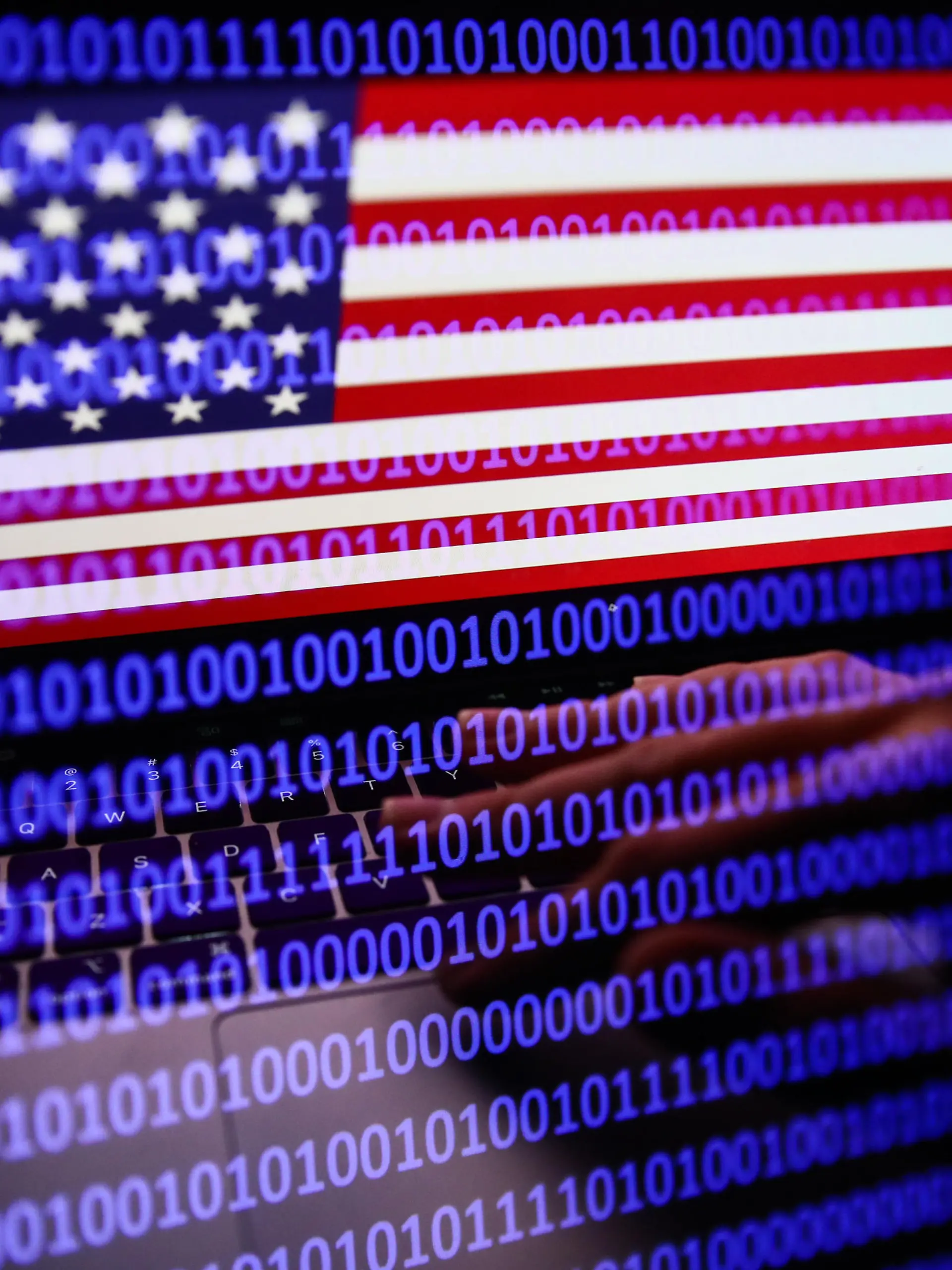 Flag of the United States displayed on a laptop screen and binary code displayed on a screen are seen in this multiple exposure illustration photo taken in Krakow, Poland on September 27, 2022. (Photo by Jakub Porzycki/NurPhoto)