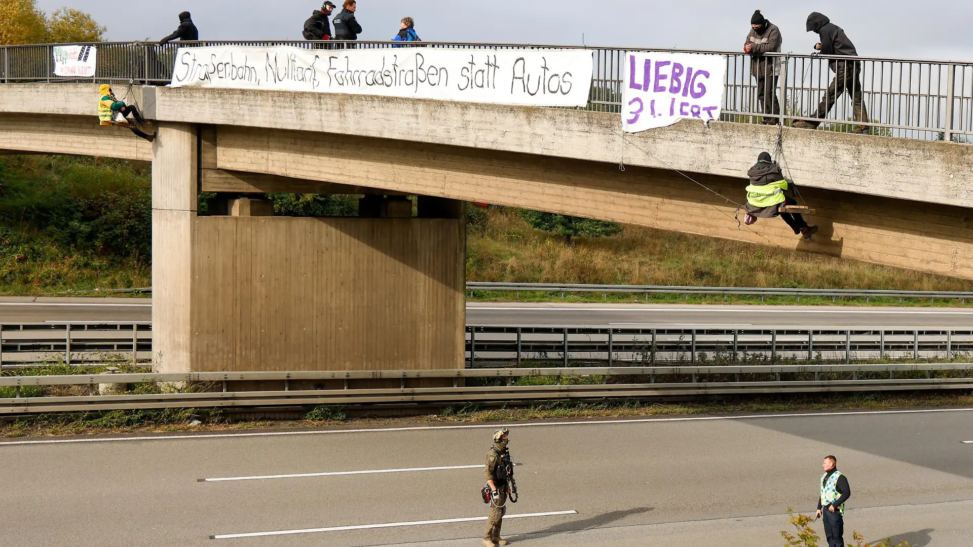 13.10.2020, Hessen, Idstein: Umweltaktivisten hängen an einer Brücke über der Autobahn 3 und protestieren gegen die Rodung von Bäumen im Herrenwald und Dannenröder Forst bei Stadtallendorf im Zusammenhang mit dem geplanten Ausbau der Autobahn 49.  (zu dpa «Nach Blockade der A3: Unfall am Stauende») Foto: Jörg Halisch/dpa +++ dpa-Bildfunk +++