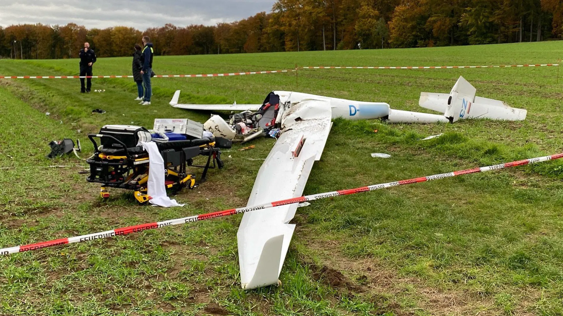 25.10.2020, Niedersachsen, Melle: Ein Absperrband umgibt ein abgestürztes Segelflugzeug auf einem Feld im Landkreis Osnabrück (bestmögliche Qualität). Ein 27 Jahre alter Pilot ist mit seinem Segelflugzeug abgestürzt und lebensgefährlich verletzt worden. Die Ursache des Absturzes ist bislang unklar. Der 27-Jährige kam in eine Klinik. Er startete den Flug von einem Segelflugplatz aus. Ein Anwohner hatte den Absturz am Sonntagvormittag gesehen und die Polizei alarmiert. Foto: -/Nord-West-Media TV /dpa - ACHTUNG: Kennung wurde aus rechtlichen Gründen gepixelt +++ dpa-Bildfunk +++