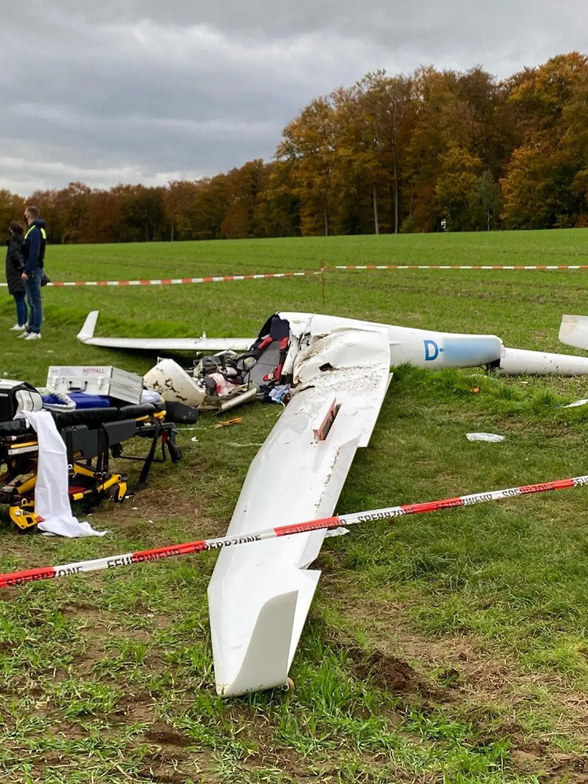 25.10.2020, Niedersachsen, Melle: Ein Absperrband umgibt ein abgestürztes Segelflugzeug auf einem Feld im Landkreis Osnabrück (bestmögliche Qualität). Ein 27 Jahre alter Pilot ist mit seinem Segelflugzeug abgestürzt und lebensgefährlich verletzt worden. Die Ursache des Absturzes ist bislang unklar. Der 27-Jährige kam in eine Klinik. Er startete den Flug von einem Segelflugplatz aus. Ein Anwohner hatte den Absturz am Sonntagvormittag gesehen und die Polizei alarmiert. Foto: -/Nord-West-Media TV /dpa - ACHTUNG: Kennung wurde aus rechtlichen Gründen gepixelt +++ dpa-Bildfunk +++