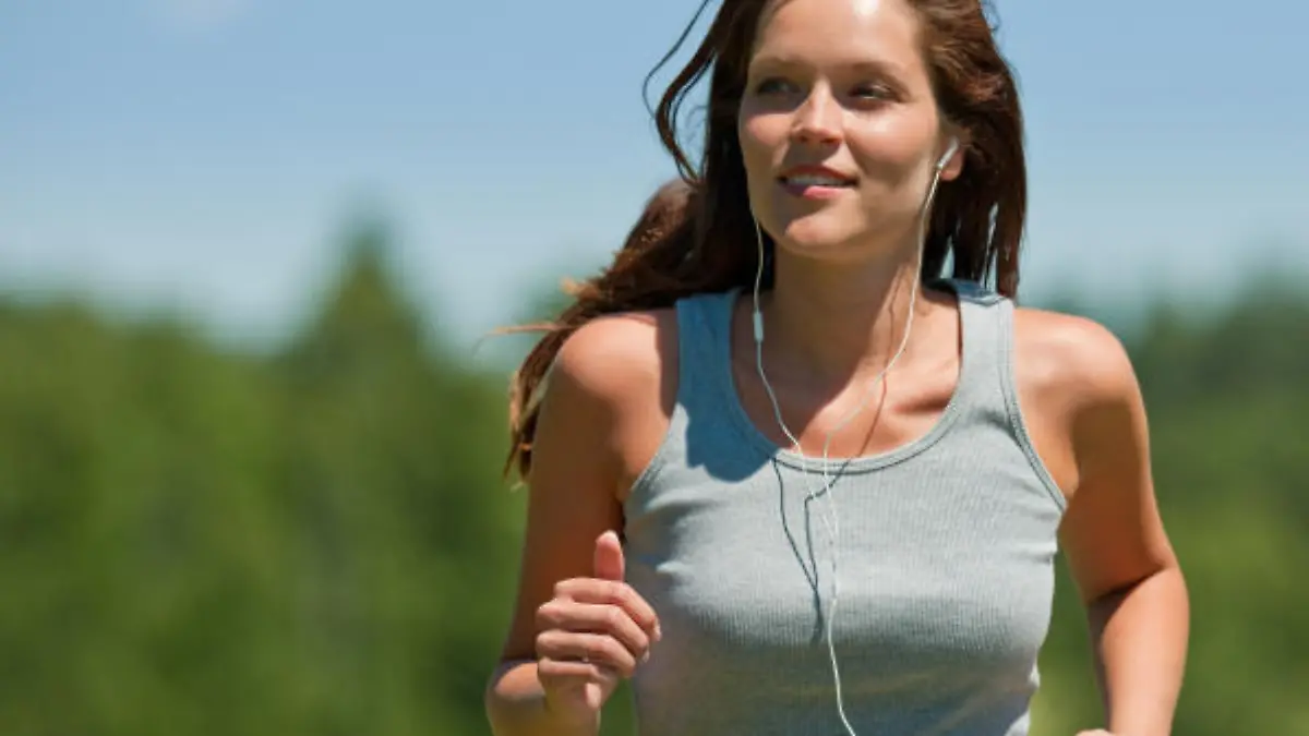 Brown hair woman with headphones jogging, man in background, shallow DOF
