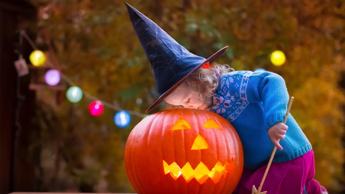 Little girl and boy carving pumpkin at Halloween. Dressed up children trick or treating. Kids trick or treat. Child in witch costume playing in autumn park. Toddler kid with jack-o-lantern.