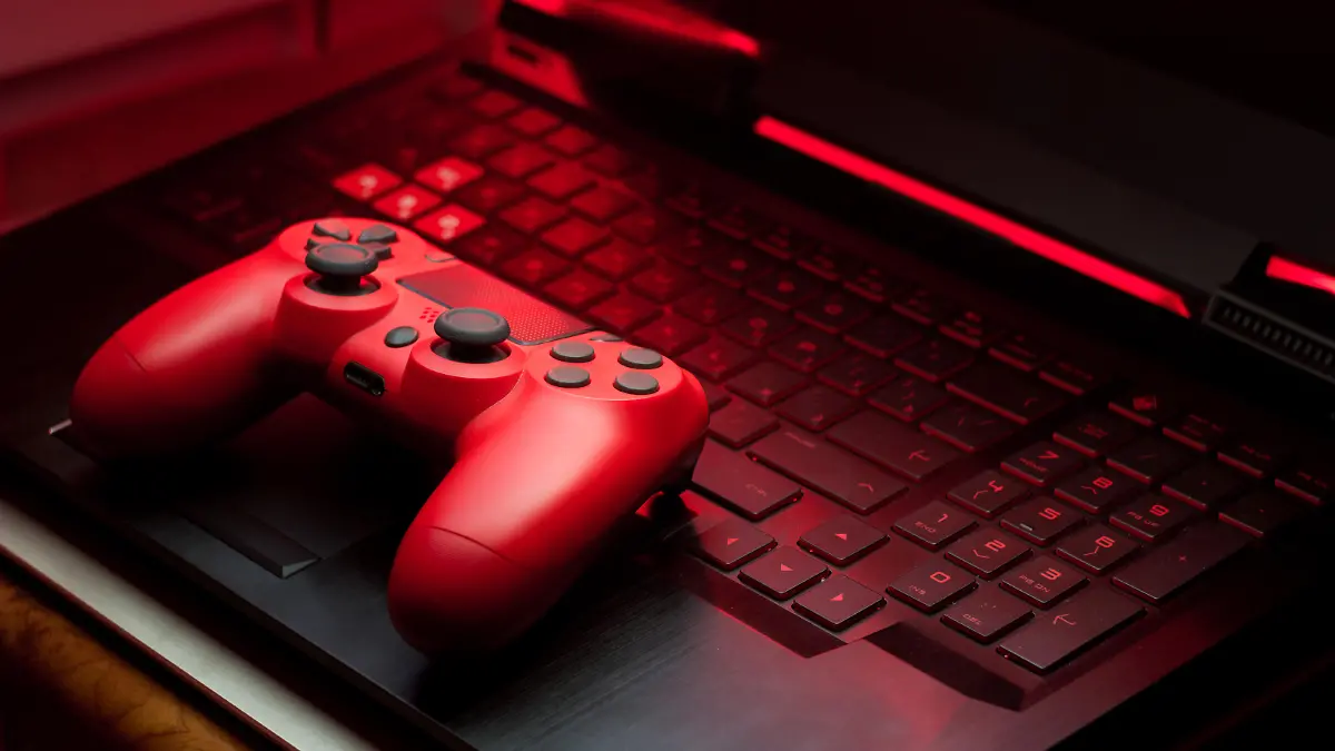 Gamepad on laptop keyboard in the dark. Video game controllers. Low key photo in the night.