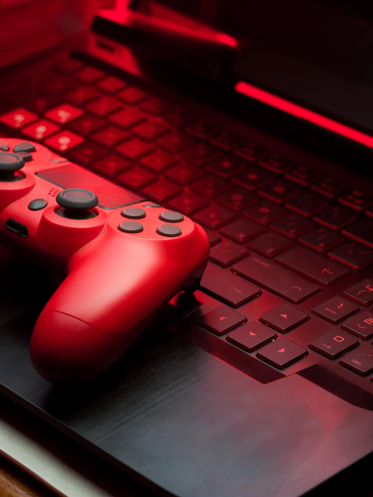 Gamepad on laptop keyboard in the dark. Video game controllers. Low key photo in the night.