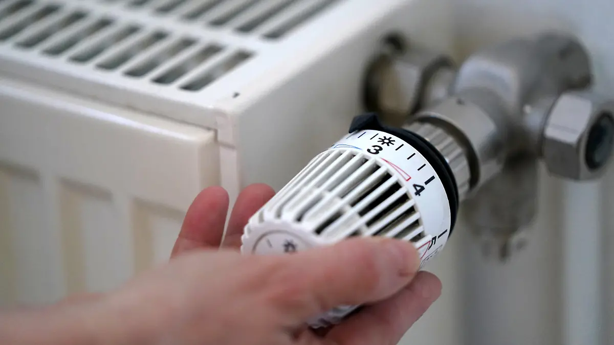 ARCHIV - 09.03.2022, Hamburg: ILLUSTRATION - Eine Frau dreht an einem Heizungsthermostat. Die Heizung zu Hause soll künftig zum Großteil mit erneuerbarer Energie laufen - das hat die Bundesregierung schon kurz nach der Wahl verabredet. Nun werden mehr Einzelheiten bekannt. Die sind aber noch hochumstritten. (zu dpa "Heizen mit mehr Wind und Sonne") Foto: Marcus Brandt/dpa +++ dpa-Bildfunk +++