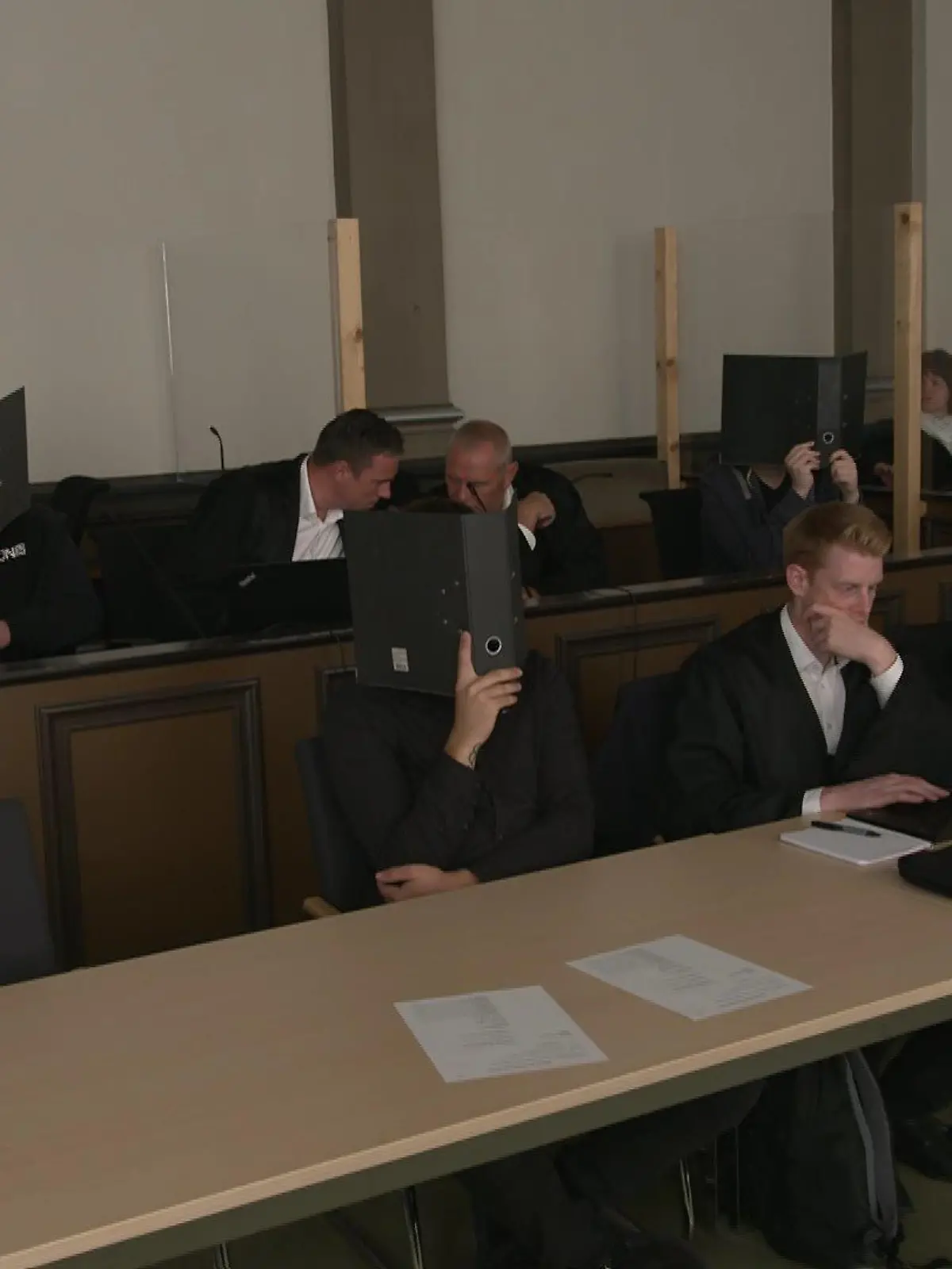 Die Angeklagten, 22, 24 und 26 Jahre alt, verdecken ihre Gesichter beim Prozessauftakt vor dem Landgericht Verden.
