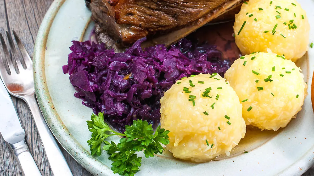 Appetizing Bavarian roast pork dish with dumplings and pretzel