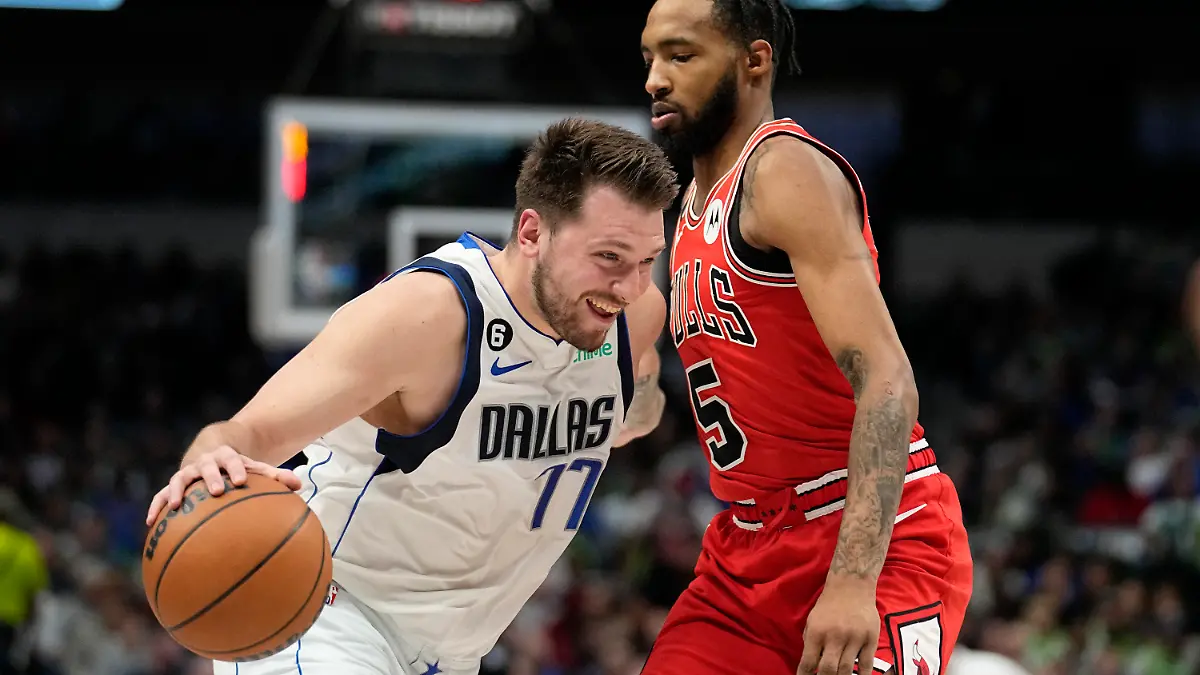 Dallas Mavericks guard Luka Doncic (77) works to shoot against Chicago Bulls forward Derrick Jones Jr., right, in the first half of an NBA basketball game Friday, April 7, 2023, in Dallas. (AP Photo/Tony Gutierrez)