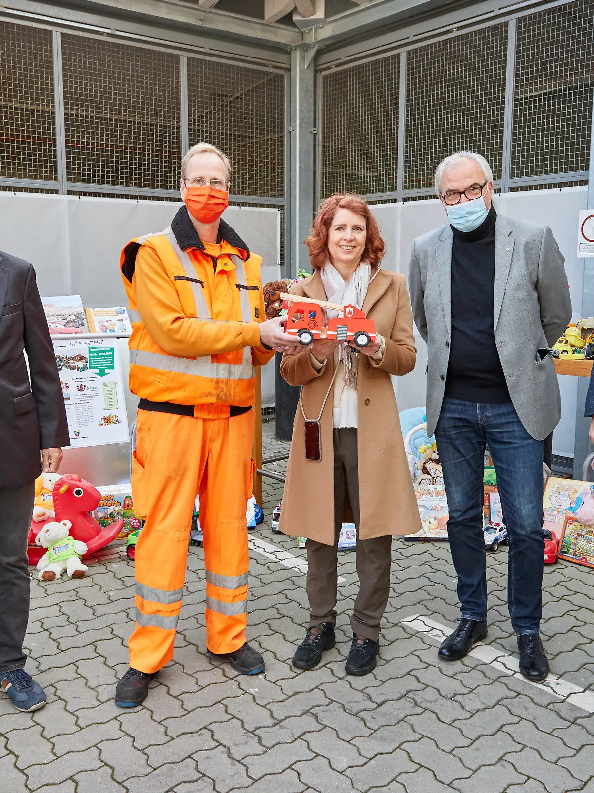 16.10.2020, Hamburg: Heinrich Fiege (l-r), Projektleiter der DEKRA Akademie Hamburg, die die Hamburger Toys Company betreibt, Jan Henning, Mitarbeiter des Recyclinghofs und Baggerfahrer, Monica Lierhaus, Moderatorin, Rolf Weber, WEISSER RING, und Holger Lange, Geschäftsführer der Stadtreinigung Hamburg, stehen während eines Pressetermins auf dem Recyclinghof Liebigstraße in Hamburg-Billbrook vor aufgestellten Spielsachen. Die Stadtreinigung startete die Sammlung von gebrauchtem Spielzeug für bedürftige Kinder. Foto: Georg Wendt/dpa +++ dpa-Bildfunk +++