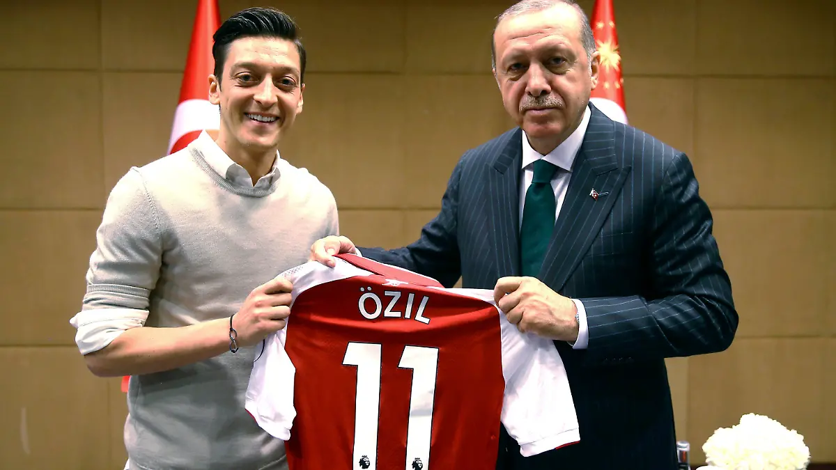 ARCHIV - 14.05.2018, Großbritannien, London: Recep Tayyip Erdogan (r), Staatspräsident der Türkei, hält zusammen mit Fußballspieler Mesut Özil vom englischen Premier League Verein FC Arsenal, ein Trikot von Özil. Der frühere Weltmeister Özil hat seine Karriere als Fußball-Profi mit 34 Jahren beendet. Der 92-malige Nationalspieler gab seine Entscheidung am Freitag bekannt. Der 92-malige deutsche Nationalspieler gab seinen sofortigen Rücktritt am Mittwoch auf seinen verifizierten Profilen bei Twitter, Instagram und Facebook bekannt. Foto: Pool Presdential Press Service/AP/dpa - ACHTUNG: Nur zur redaktionellen Verwendung und nur mit vollständiger Nennung des vorstehenden Credits +++ dpa-Bildfunk +++