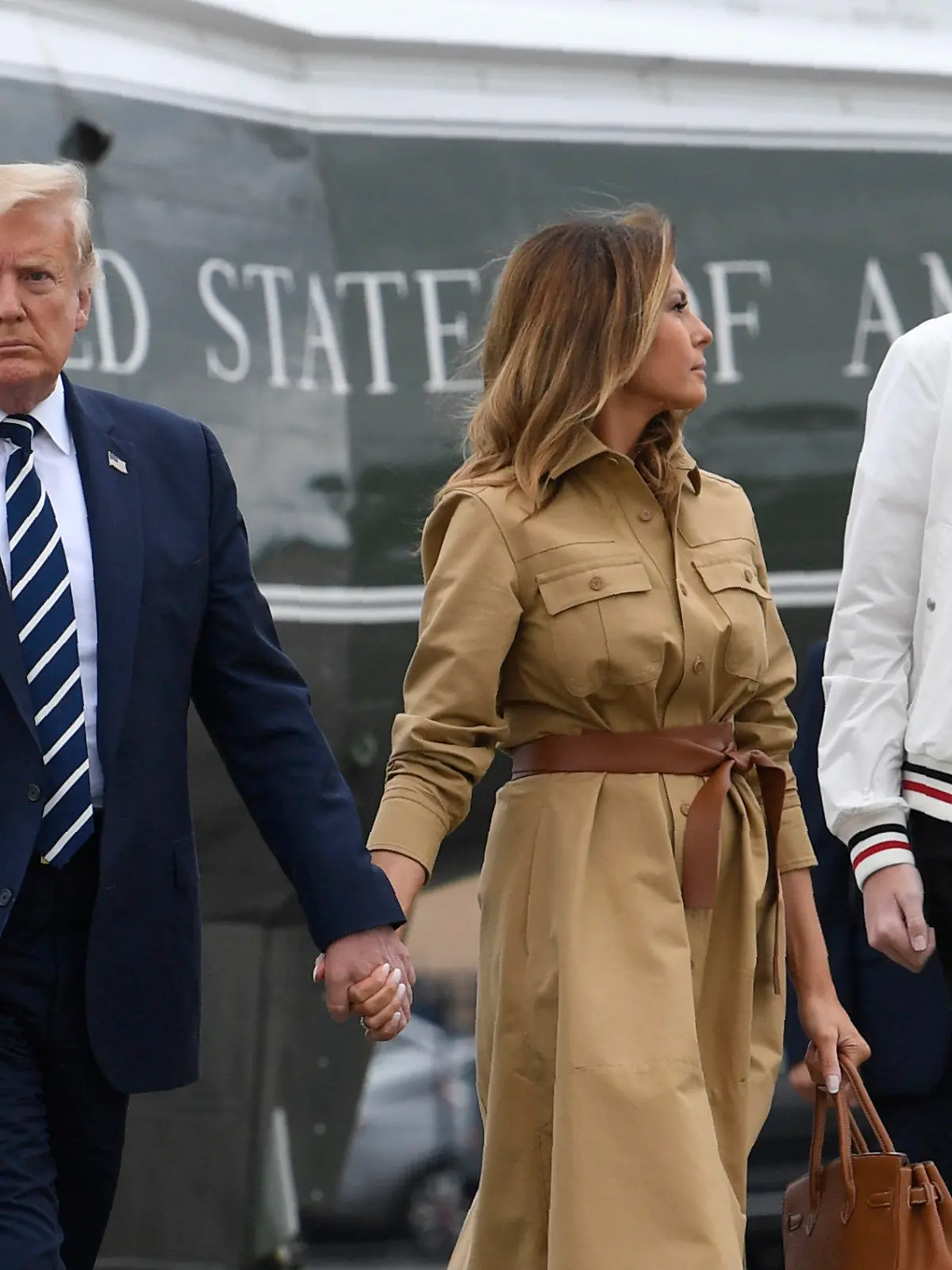 FILE - In this Aug. 16, 2020 file photo, President Donald Trump, first lady Melania Trump and their son, Barron Trump, walk off of Marine One and head toward Air Force One at Morristown Municipal Airport in Morristown, N.J. (AP Photo/Susan Walsh)