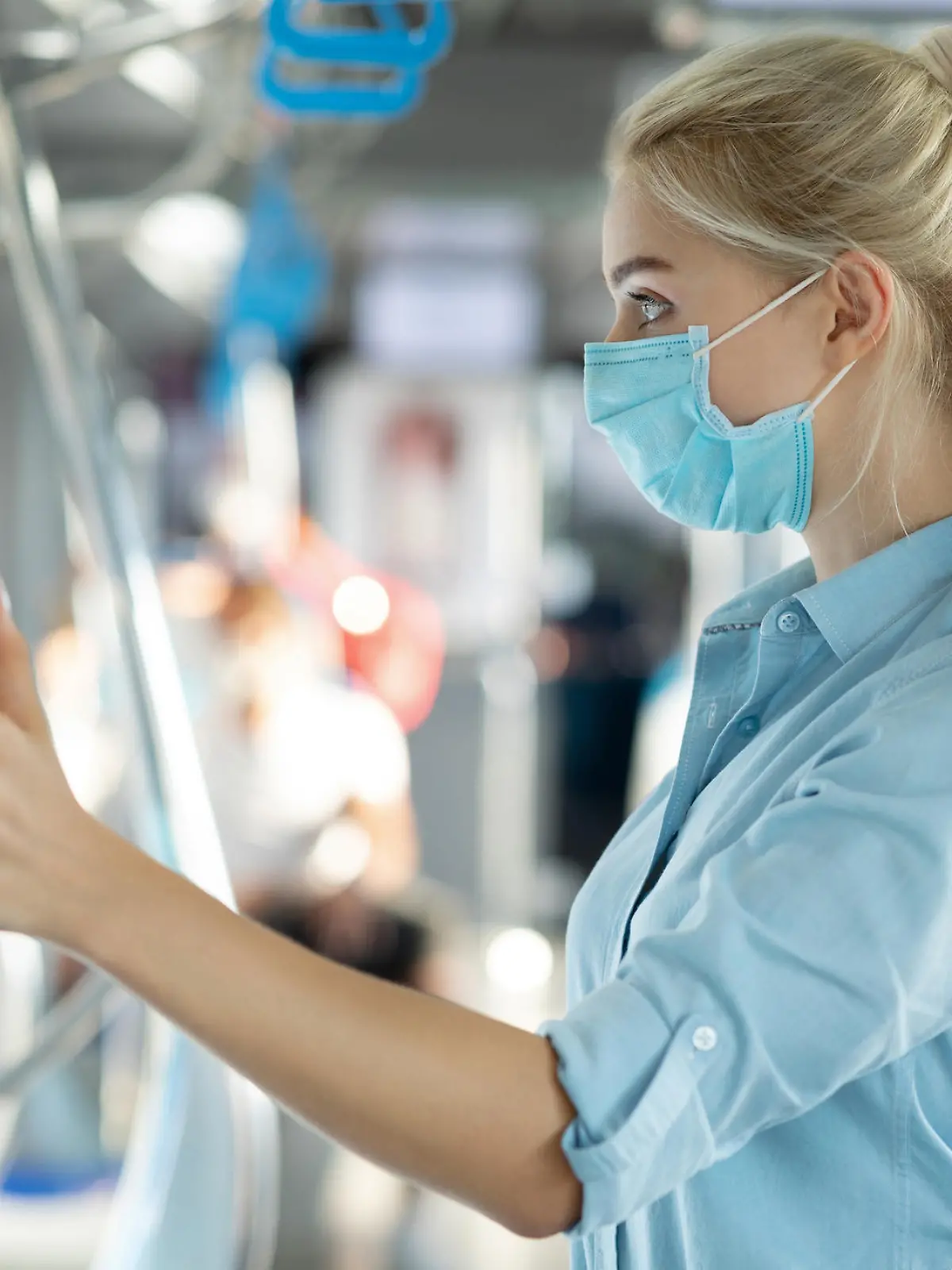 Frau fasst Stange in der Bahn an
