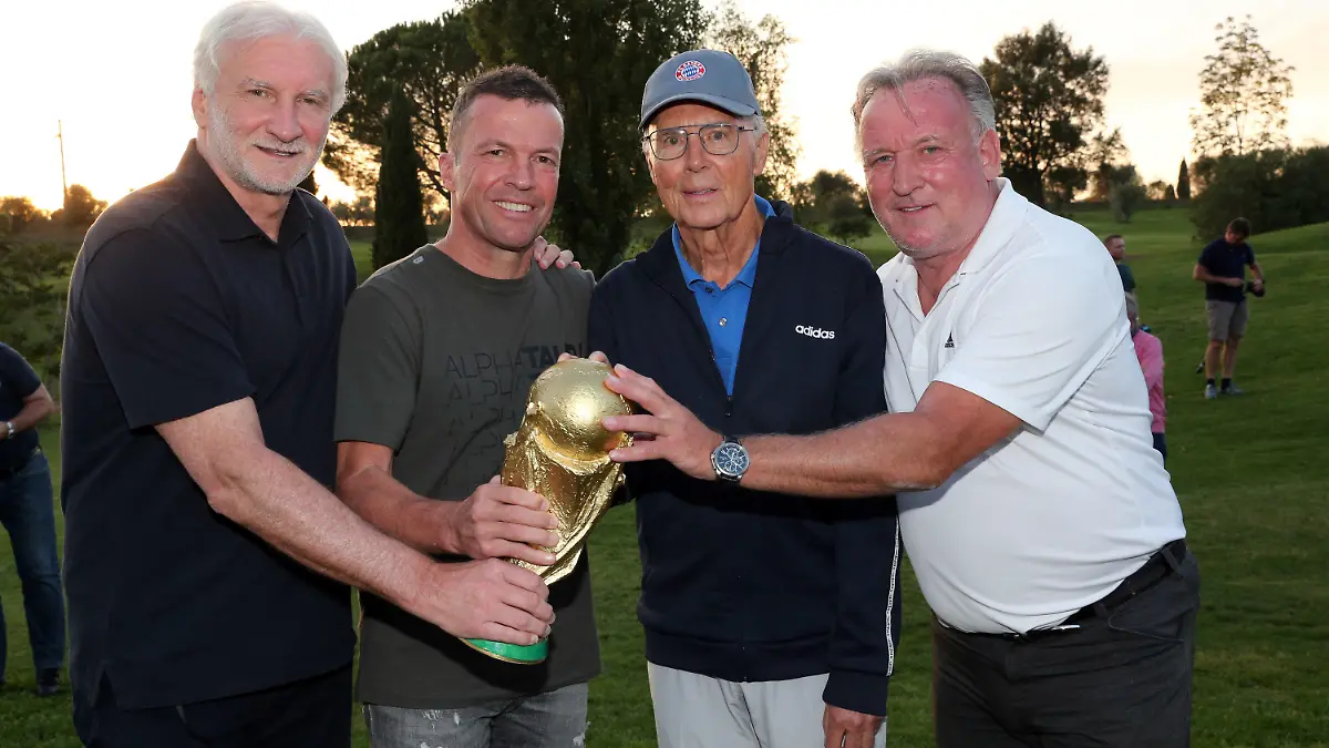 HANDOUT - 10.10.2020, Italien, Grosseto: Rudi Völler (l-r), früherer Nationalspieler, Lothar Matthäus, ehemaliger Kapitän der Nationalmannschaft, Franz Beckenbauer, ehemaliger Trainer der Nationalmannschaft, und Andreas Brehme, Finaltorschütze der Fußball-WM von 1990, halten einen goldenen Pokal in den Händen. 15 der 22 Fußball-Weltmeister von 1990 feierten in der Toskana das 30-jährige Jubiläum ihres Triumphes. Die deutsche Mannschaft hatte am 8. Juli 1990 das Endspiel in Rom gegen Argentinien mit 1:0 gewonnen. (zu dpa «Weltmeister von 1990 feiern Titeljubiläum: Waren «perfektes Team») Foto: Gisela Schober/Getty Images/dpa - ACHTUNG: Nur zur redaktionellen Verwendung im Zusammenhang mit der aktuellen Berichterstattung und nur mit vollständiger Nennung des vorstehenden Credits +++ dpa-Bildfunk +++