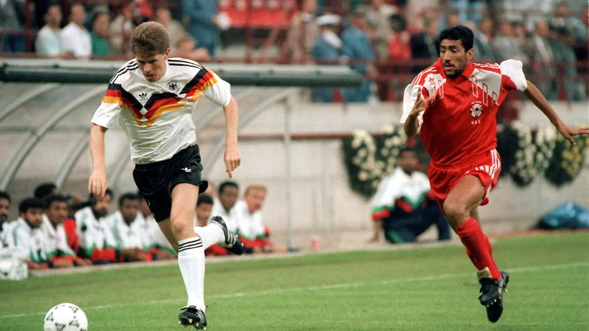 Der deutsche Abwehrspieler Stefan Reuter (l) überläuft einen VAE-Gegenspieler. Die deutsche Fußballnationalmannschaft gewinnt bei der Weltmeisterschaft in Italien am 15.06.1990 im Mailänder Giuseppe-Meazza-Stadion vor 71.200 Zuschauern das Gruppenspiel gegen die Elf der Vereinigten Arabischen Emirate mit 5:1. +++(c) dpa - Report+++