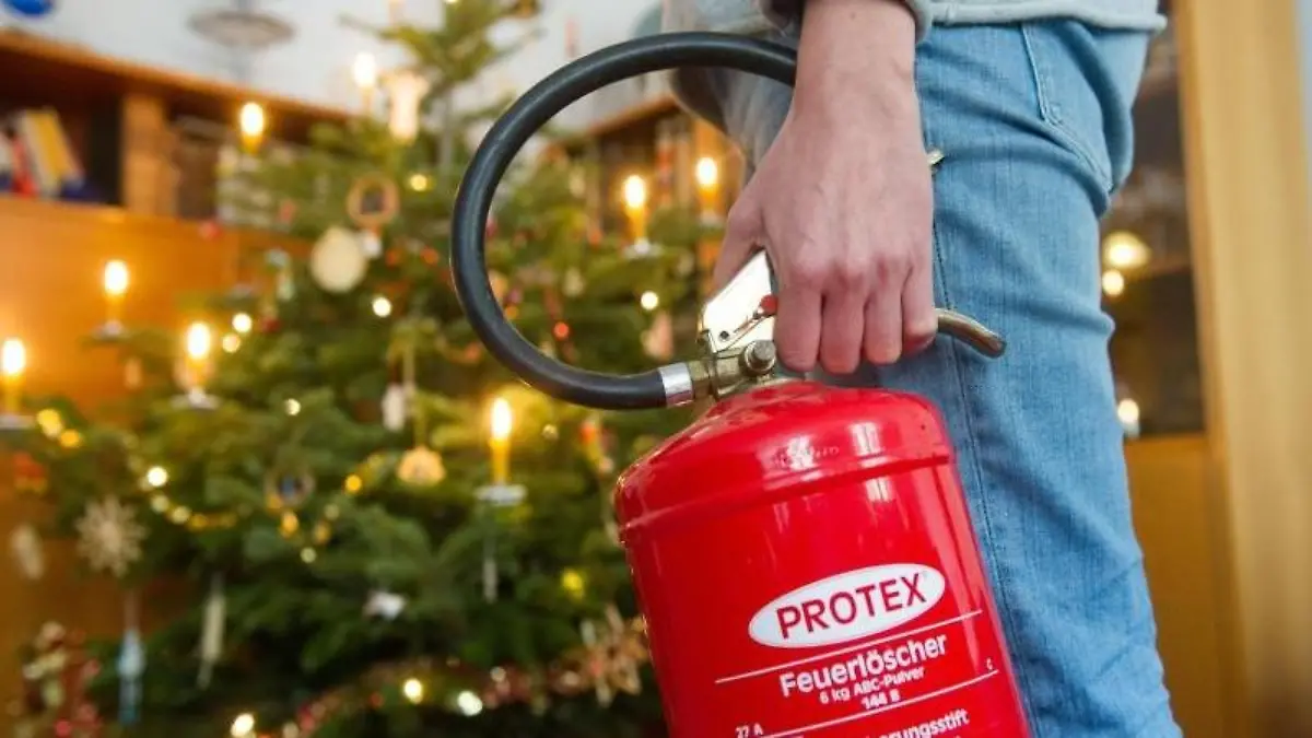 Den Feuerlöscher immer griffbereit haben - wer echte Kerzen an seinem Weihnachtsbaum verwendet, muss wachsam sein. Foto: Tobias Hase