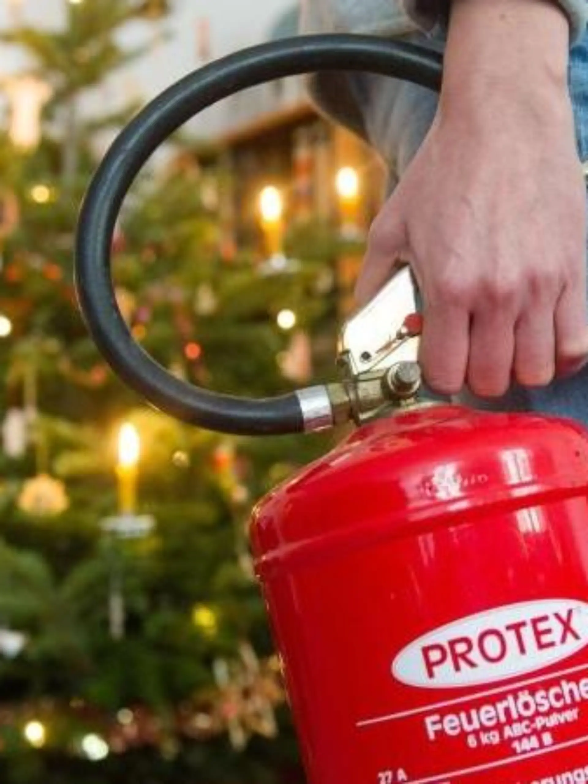 Den Feuerlöscher immer griffbereit haben - wer echte Kerzen an seinem Weihnachtsbaum verwendet, muss wachsam sein. Foto: Tobias Hase