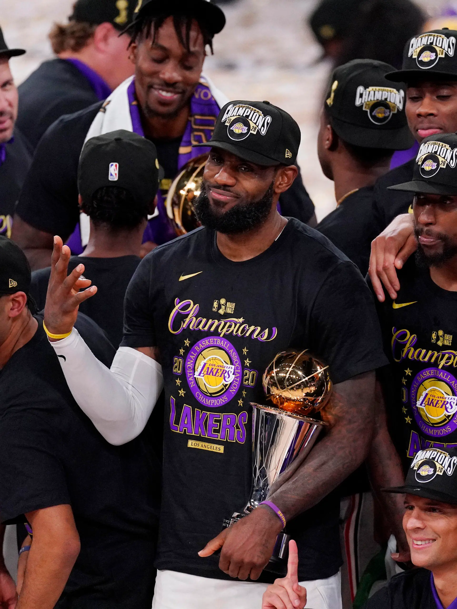 11.10.2020, USA, Lake Buena Vista: Basketball: NBA, Miami Heat - Los Angeles Lakers,Play-off-Runde, NBA-Finale, Finale, 6. Spieltag. LeBron James (M) von den Los Angeles Lakers hält die MVP-Trophäe, während er mit seinen Mannschaftskameraden den 17. NBA-Titel der Los Angeles Lakers feiert. James bekam zum vierten Mal in seiner Karriere die Auszeichnung als wertvollster Spieler der Finalserie (MVP). Foto: Mark J. Terrill/AP/dpa +++ dpa-Bildfunk +++