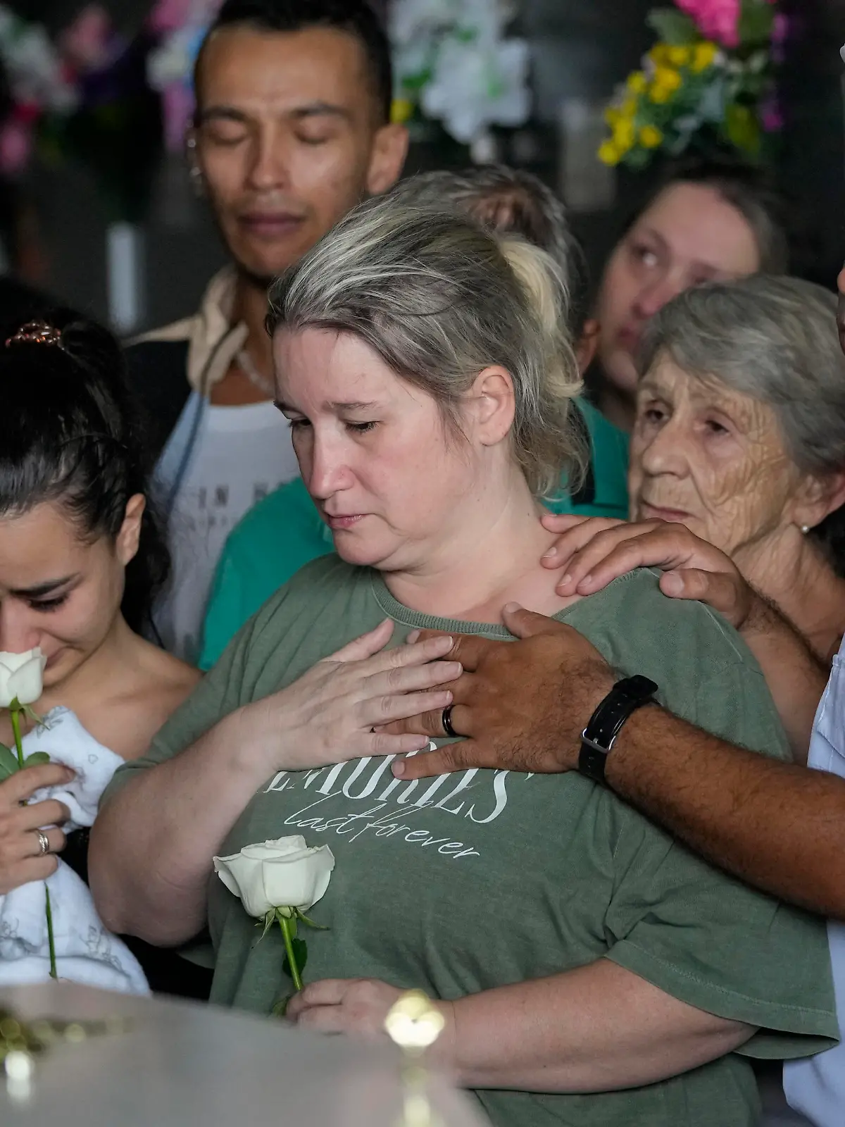 Bruno Machado, right, and his wife Neide Cunha, center, attend the funeral of their five-year-old son Bernardo who was killed by a man with a hatchet inside a day care center, at the Sao Jose cemetery in Blumenau, Santa Catarina state, Brazil, Thursday, April 6, 2023. A man with a hatchet jumped over a wall and burst into a day care center Wednesday in Brazil, killing four children, authorities said. (AP Photo/Andre Penner)