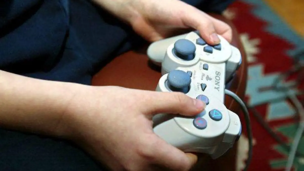 Ein sechsjähriger Junge sitzt im Wohnzimmer der Familie und spielt ein Formel-1-Playstation-Videospiel, aufgenommen am 24.1.2003 in Helsinki.