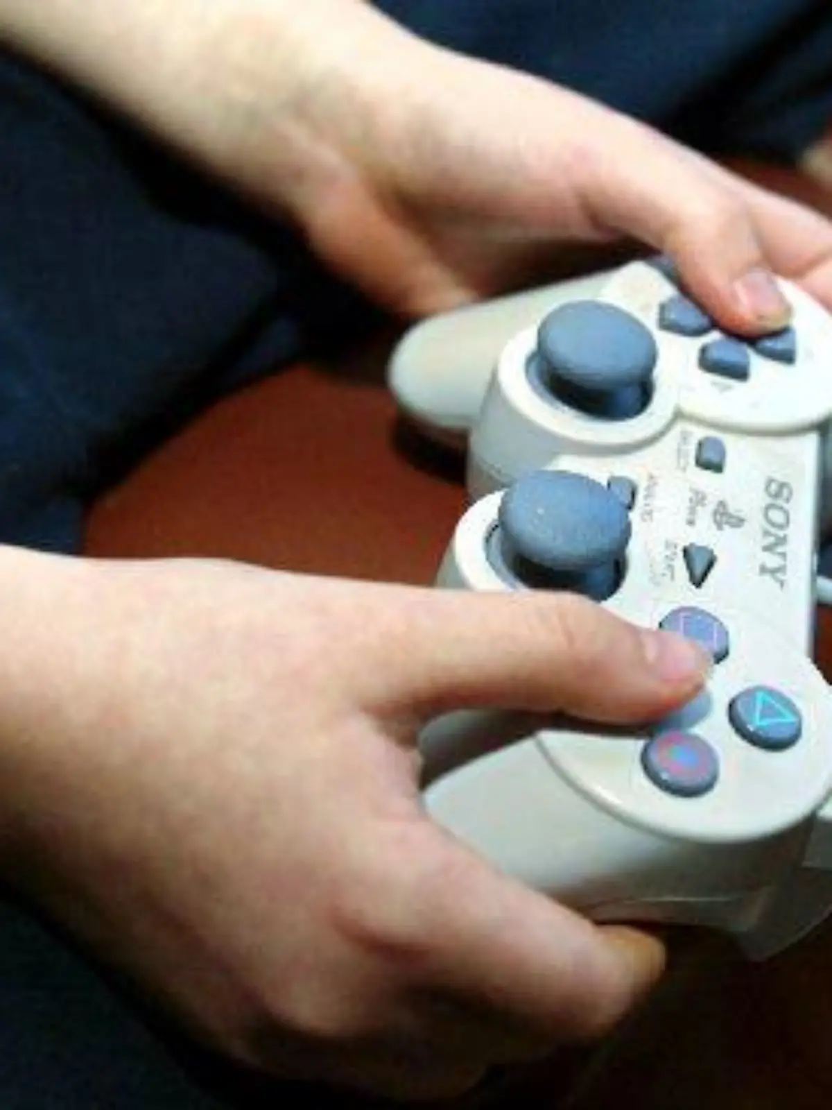 Ein sechsjähriger Junge sitzt im Wohnzimmer der Familie und spielt ein Formel-1-Playstation-Videospiel, aufgenommen am 24.1.2003 in Helsinki.