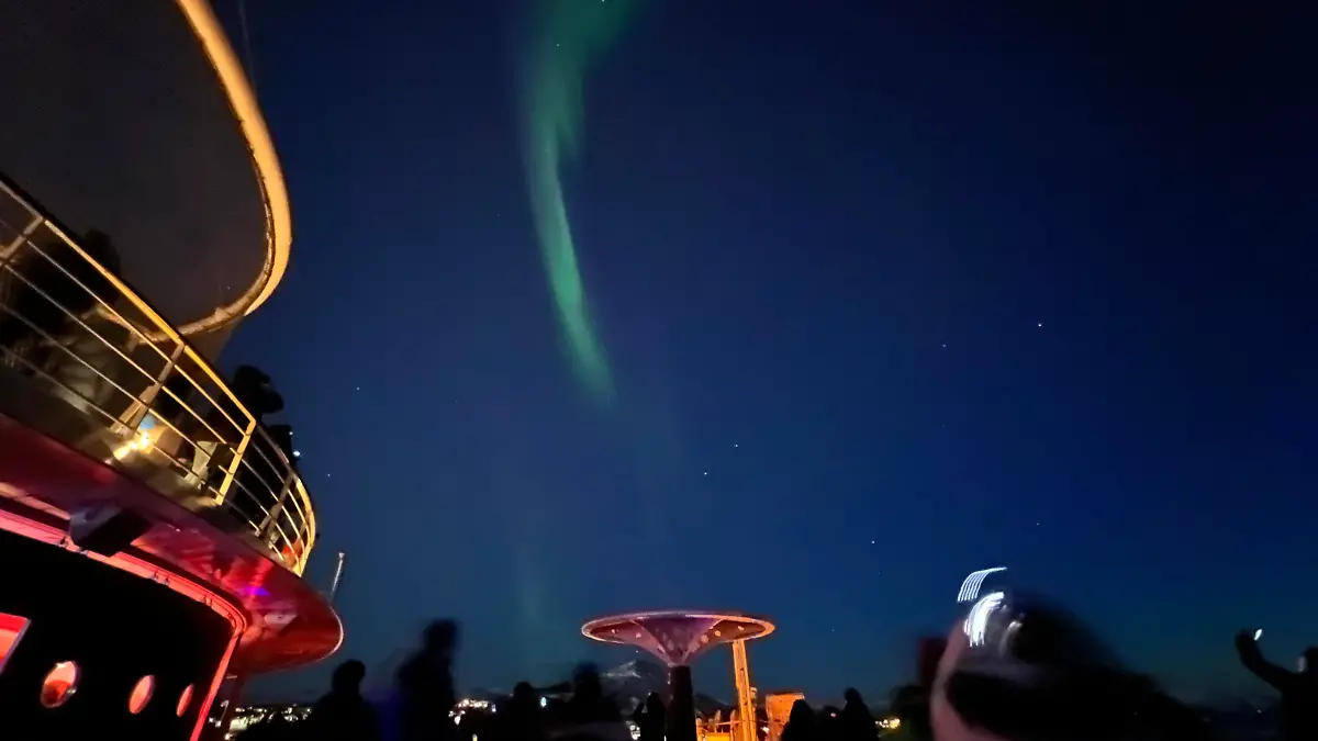 Auf Deck 12 achtern tummeln sich die Passagiere der Aida mar. Die Urlauber fotografieren die Polarlichter, die am Nachthimmel von Alta (Norwegen) zu sehen sind.