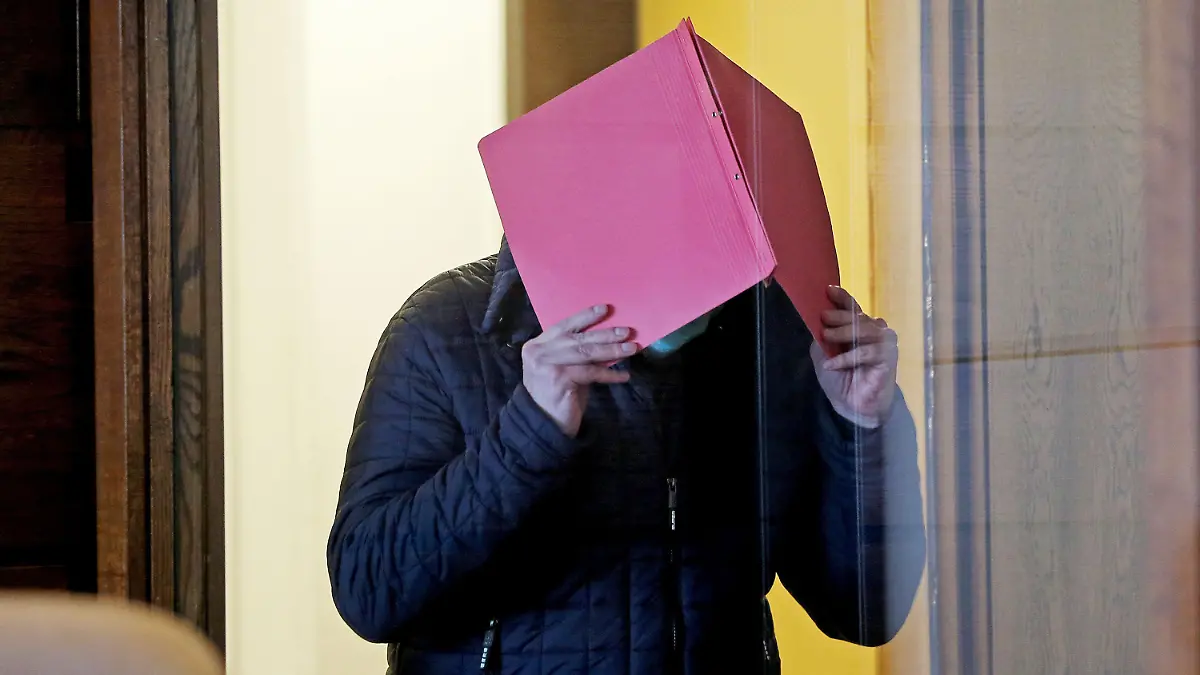 06.10.2020, Nordrhein-Westfalen, Köln: Der Angeklagte im Prozess wegen schweren sexuellen Missbrauchs von Kindern kommt in den Gerichtssaal, während er sich eine Mappe vor das Gesicht hält. Im Missbrauchskomplex Bergisch Gladbach ist der Angeklagte zu zwölf Jahren Haft verurteilt worden. Foto: Oliver Berg/dpa +++ dpa-Bildfunk +++