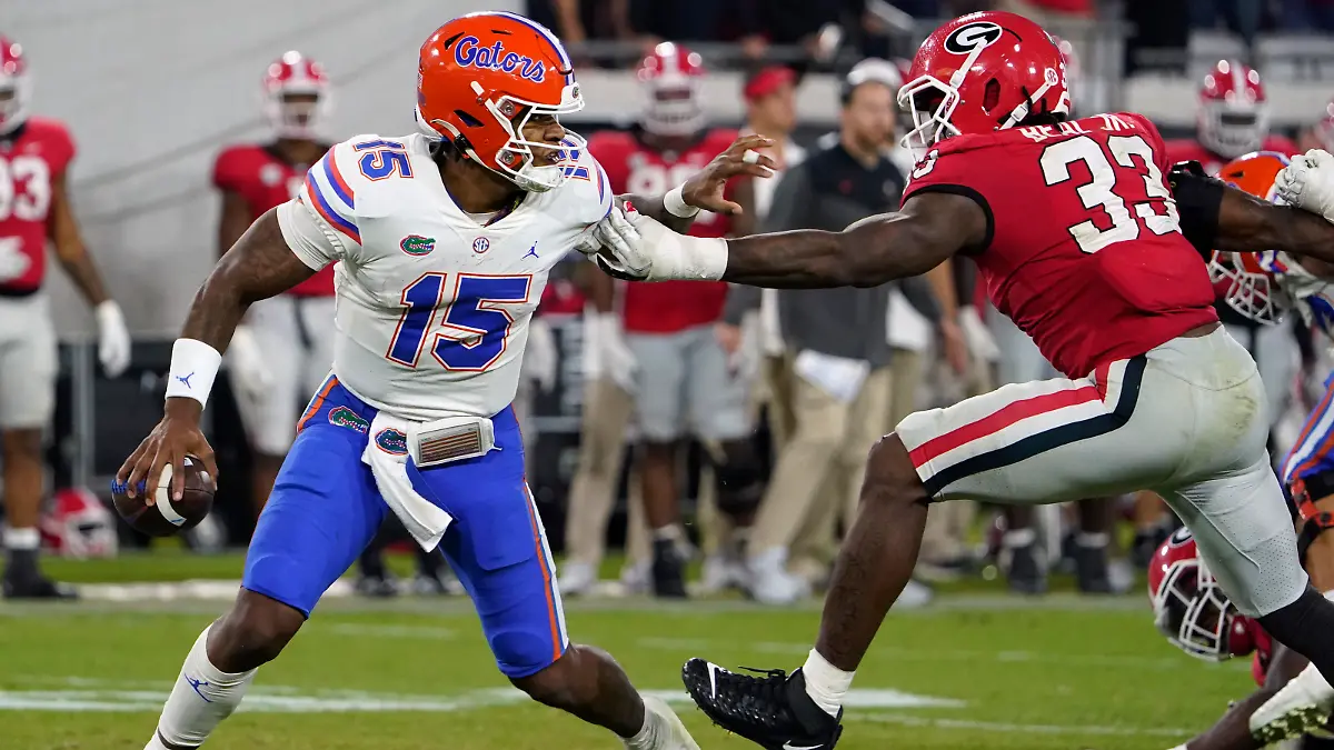 Florida quarterback Anthony Richardson (15) dodges a tackle by Georgia linebacker Robert Beal Jr. (33) during the second half of an NCAA college football game Saturday, Oct. 29, 2022, in Jacksonville, Fla. (AP Photo/John Raoux)
