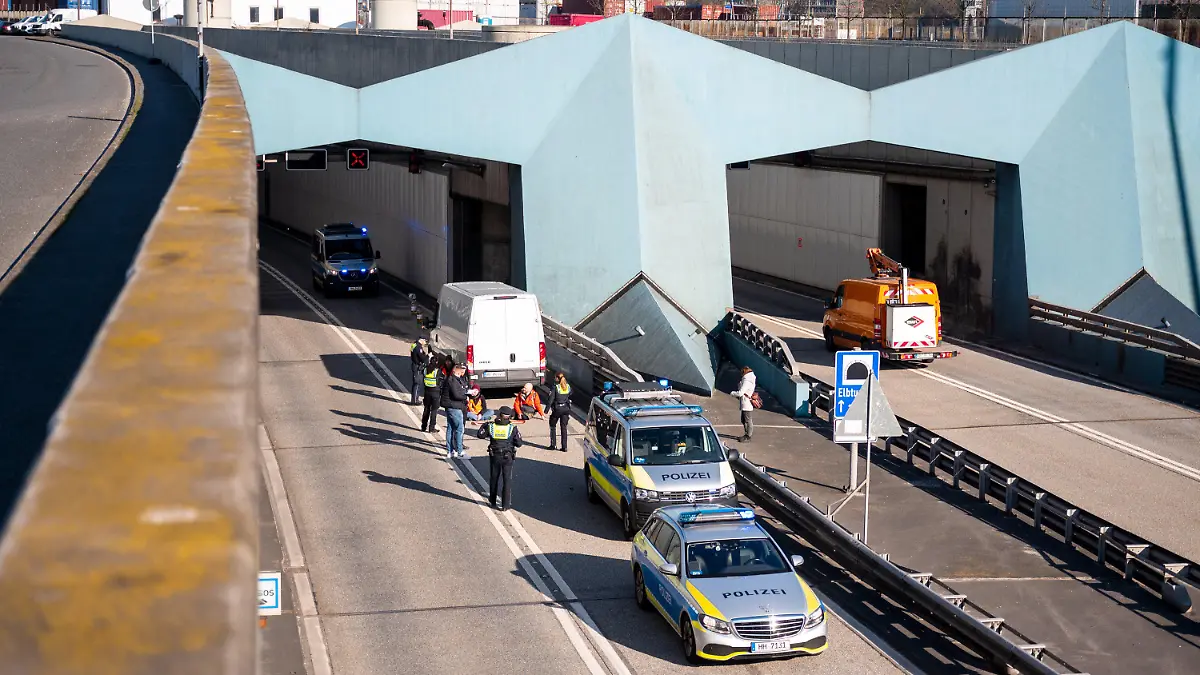 06.04.2023, Hamburg: Klimaaktivisten haben sich auf der Fahrbahn der Autobahn 7 festgeklebt und blockieren so die Zufahrt des Elbtunnels in Richtung Norden. Foto: Daniel Bockwoldt/dpa +++ dpa-Bildfunk +++